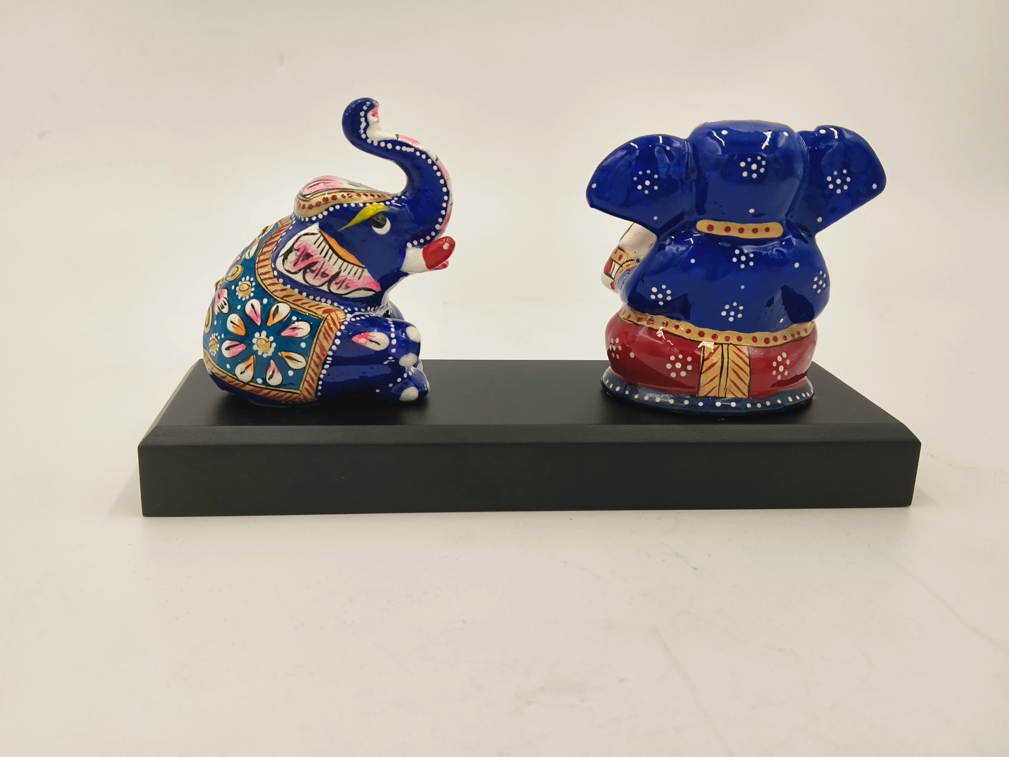 Blue and red brass Ganesh sculpture with elephant detail on black base