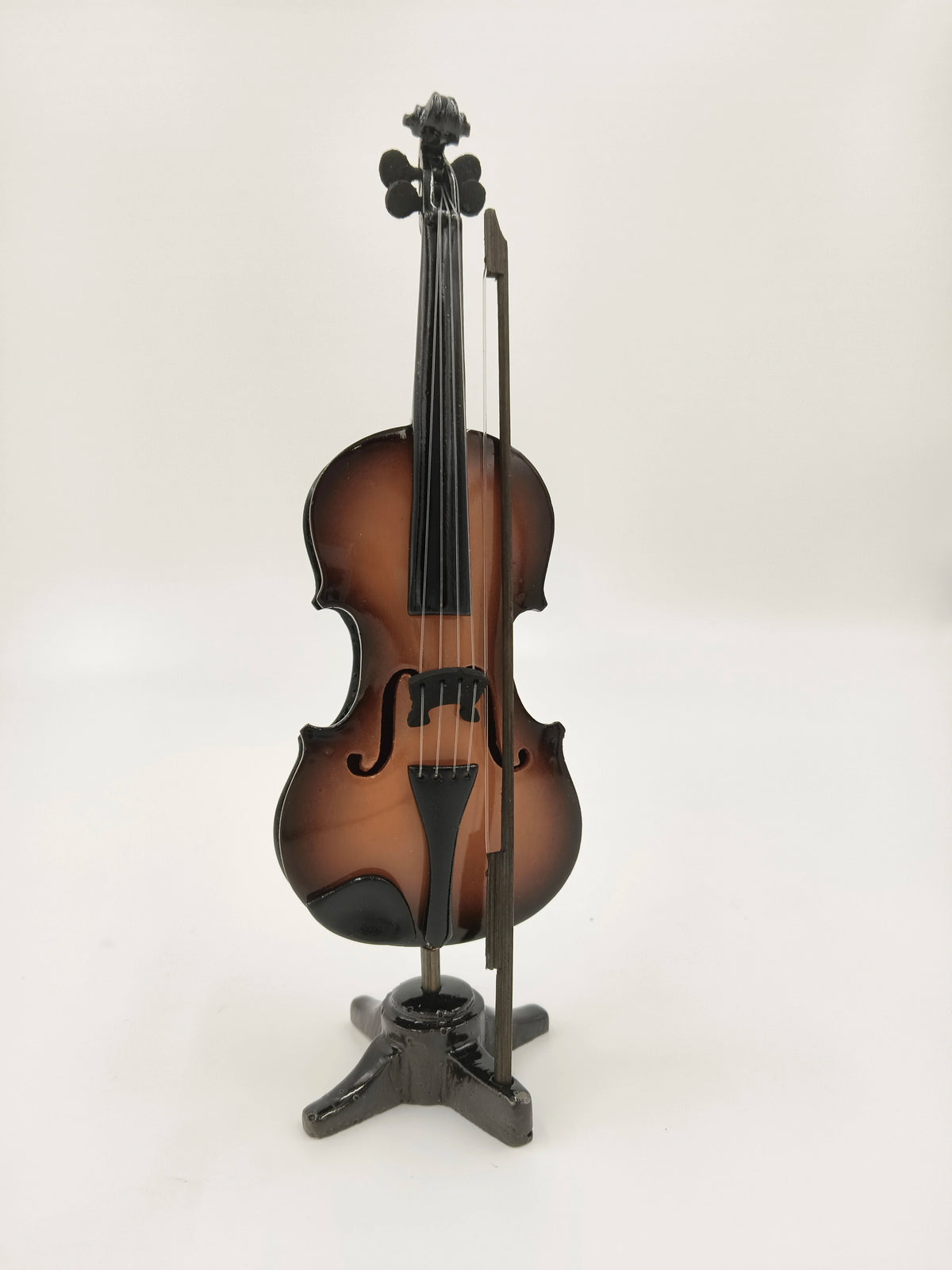 Large wooden violin sculpture with bow on black stand