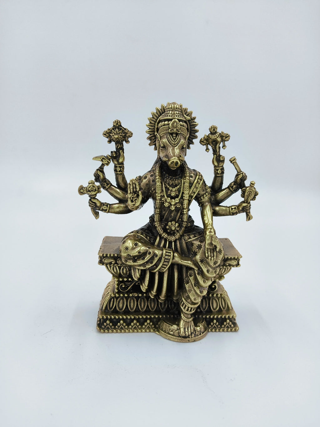 Small brass Varahi deity sculpture with six arms seated on a decorated pedestal