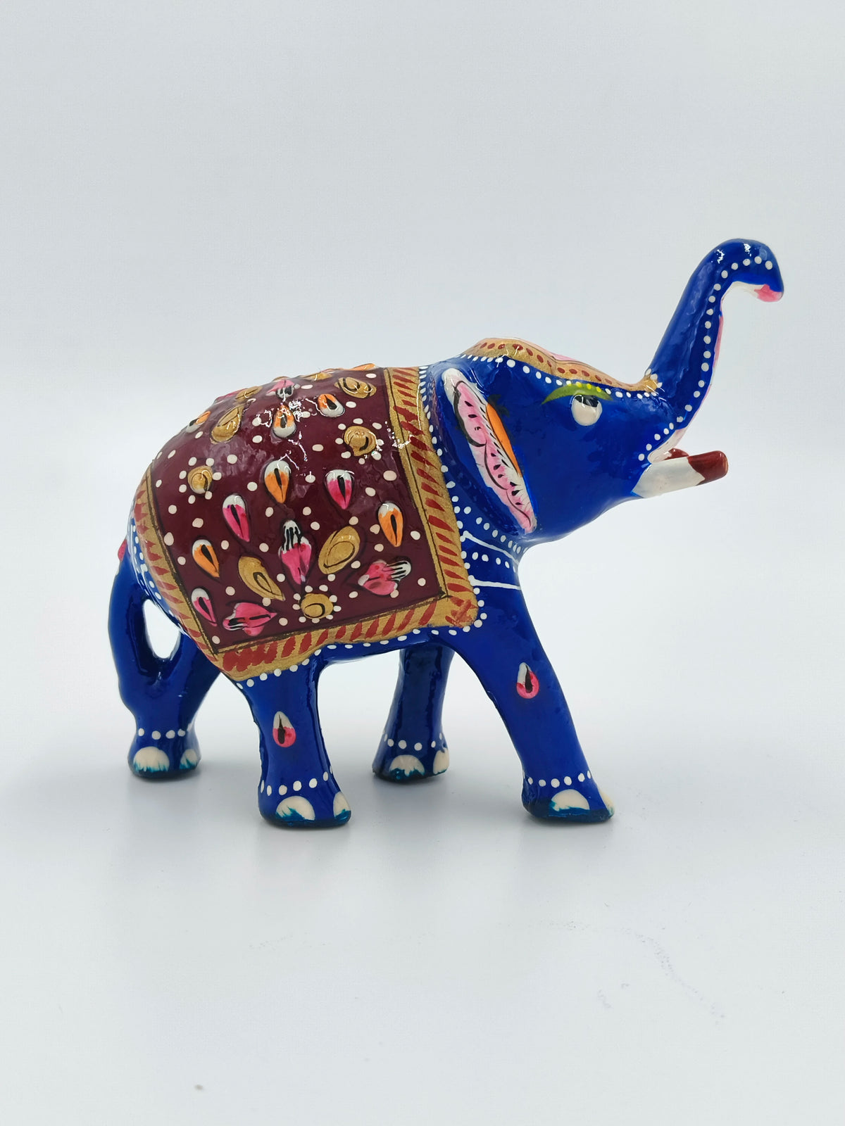 Small blue enamel elephant figurine with red and gold decorative saddle detail