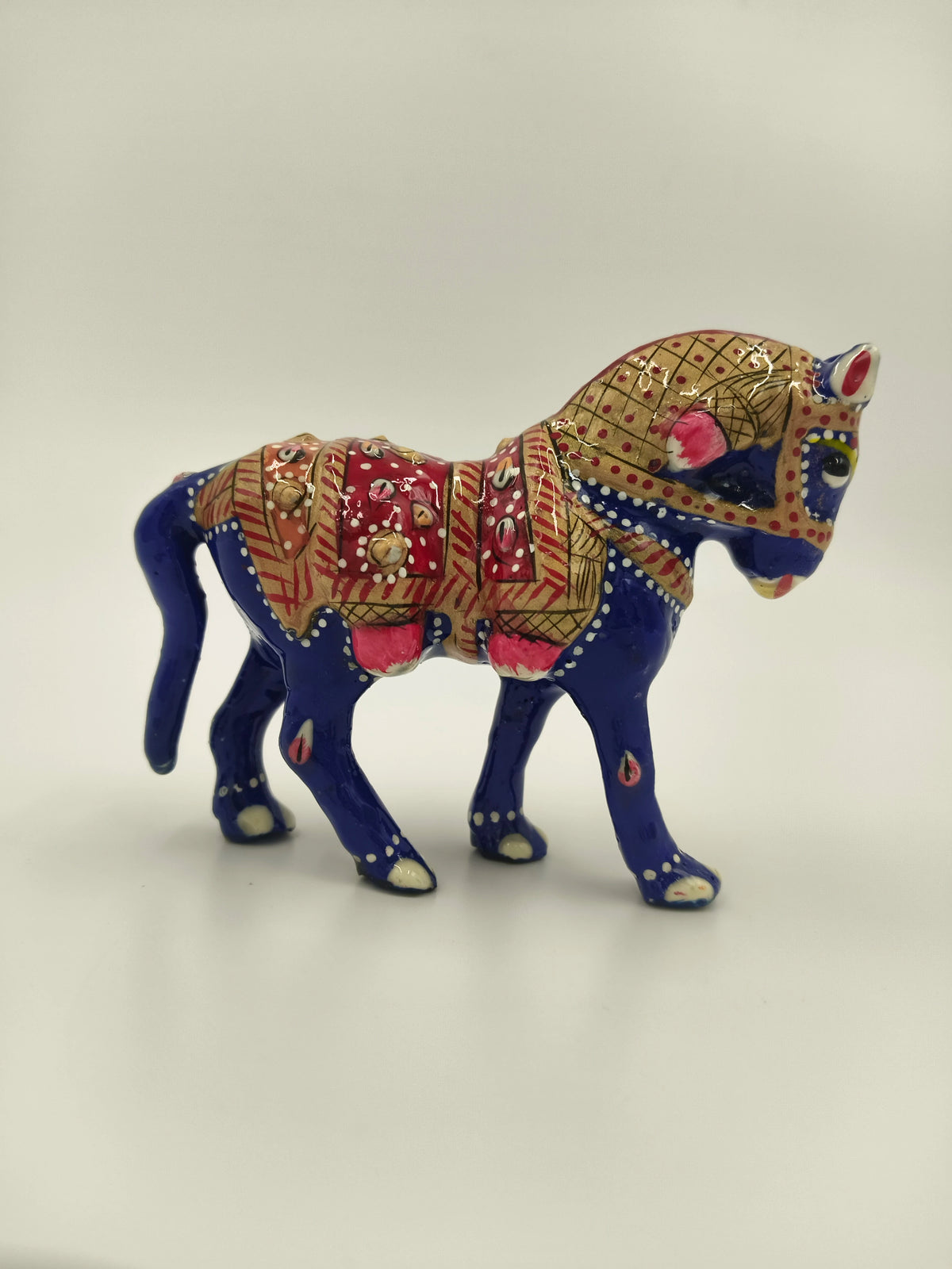 small blue enamel horse figurine with red and gold decorative patterns side view