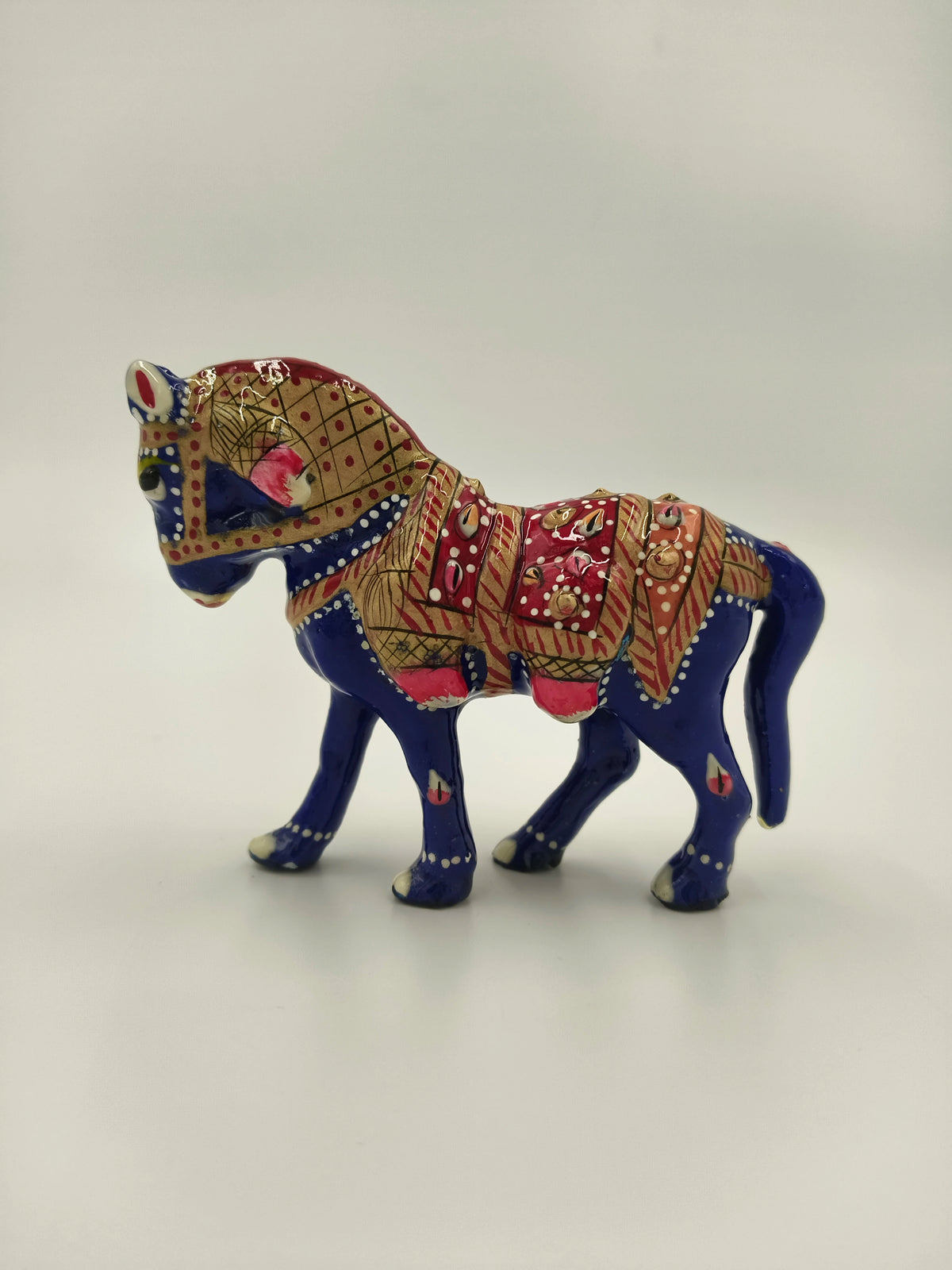 Small blue enamel horse figurine with red and gold decorative patterns side view