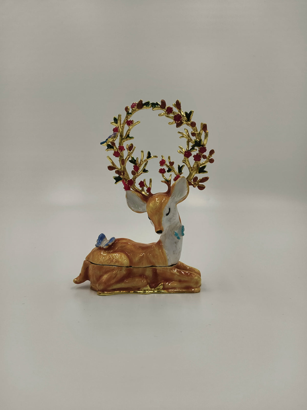 Medium-sized brass enamel deer figurine with decorated antlers and butterflies