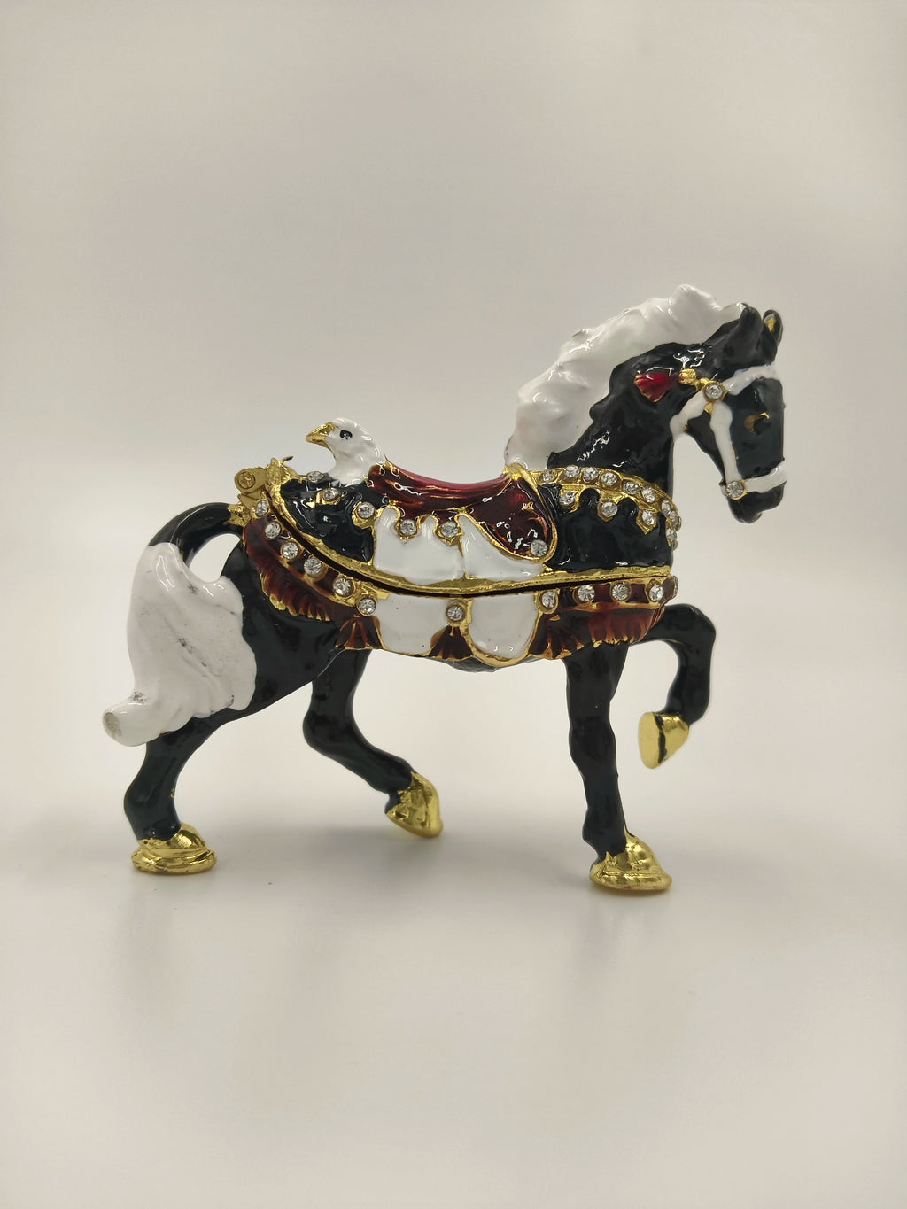 Small brass black horse figurine with white mane and gold accents side view