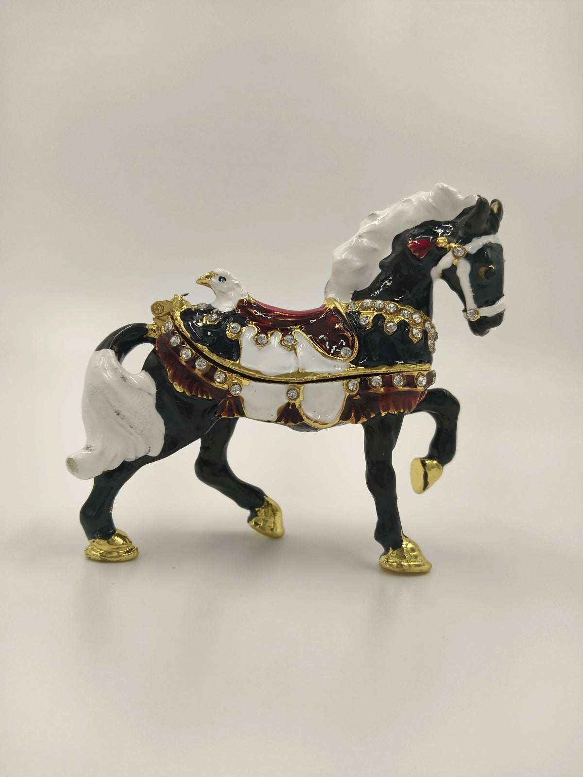 Small brass black horse figurine with white mane and gold accents side view