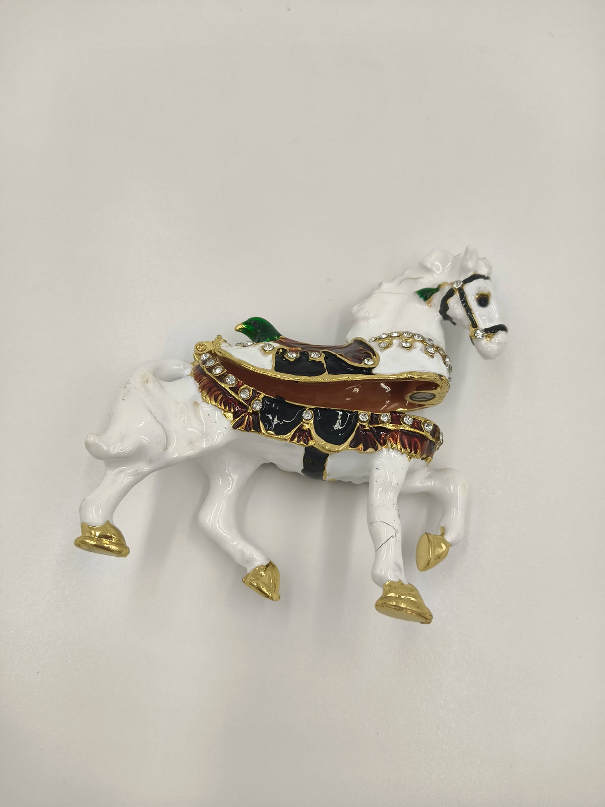 Small brass and enamel white horse figurine with decorative saddle and gold accents