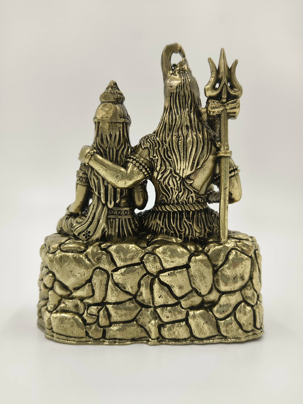 Rear view of small brass Shiva Parvathi sculpture sitting on stone base