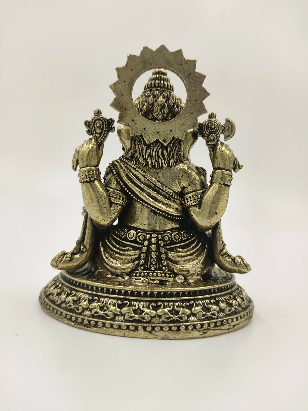 Back view of small brass Ganesh statue with detailed carvings