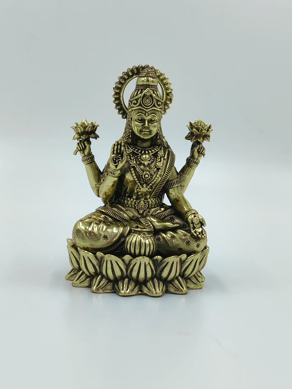 Small brass statue of Lakshmi holding lotuses seated on lotus pedestal