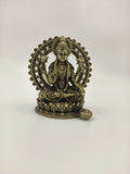 Small brass sculpture of Lakshmi seated inside a decorative arch