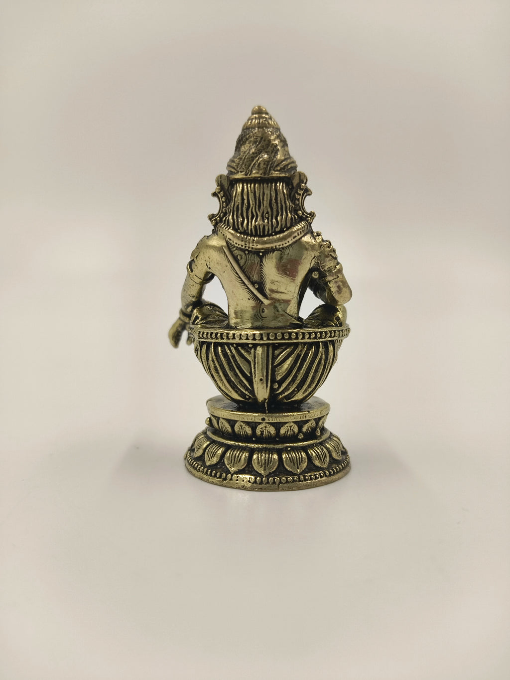 Back view of a mini brass Ayyappa statue seated on a decorative base