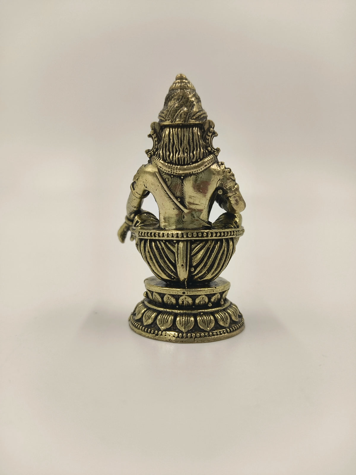 Back view of a mini brass Ayyappa statue seated on a decorative base