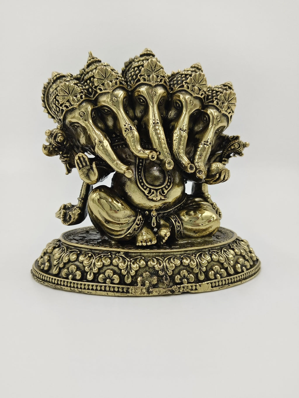 Small brass Panchamukhi Ganesha sculpture with five elephant heads sitting on ornate base