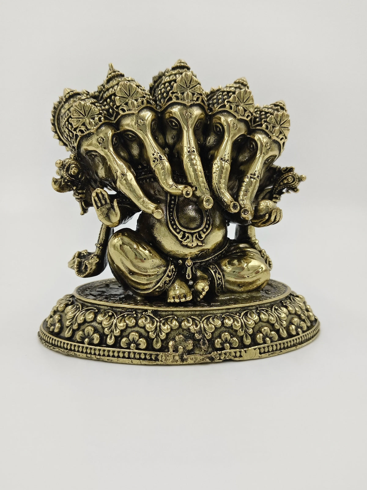 Small brass Panchamukhi Ganesha sculpture with five elephant heads sitting on ornate base