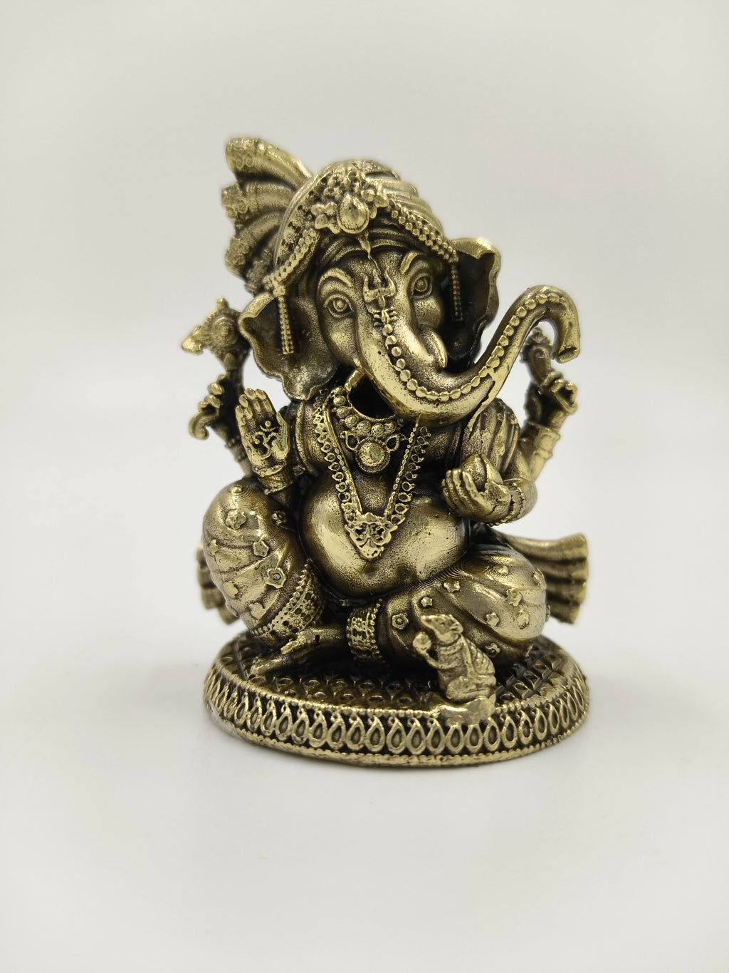 Mini brass sculpture of Ganesh deity seated with intricate detailing
