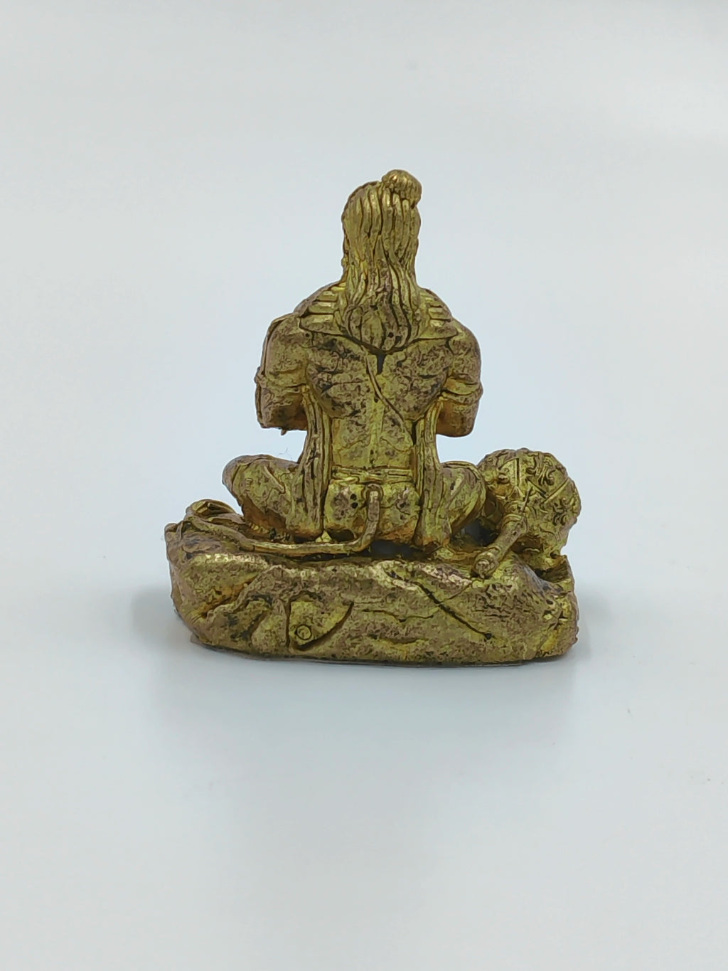 Back view of a small brass Hanuman statue seated on a base