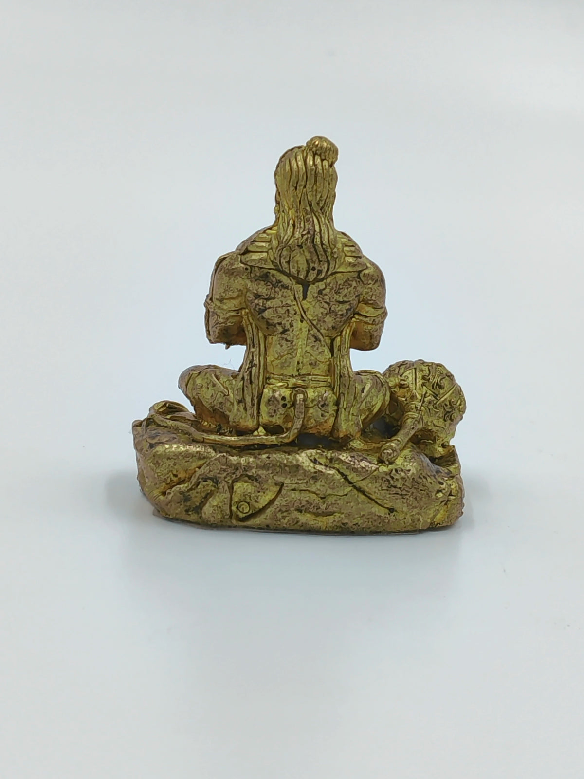 Back view of a small brass Hanuman statue seated on a base