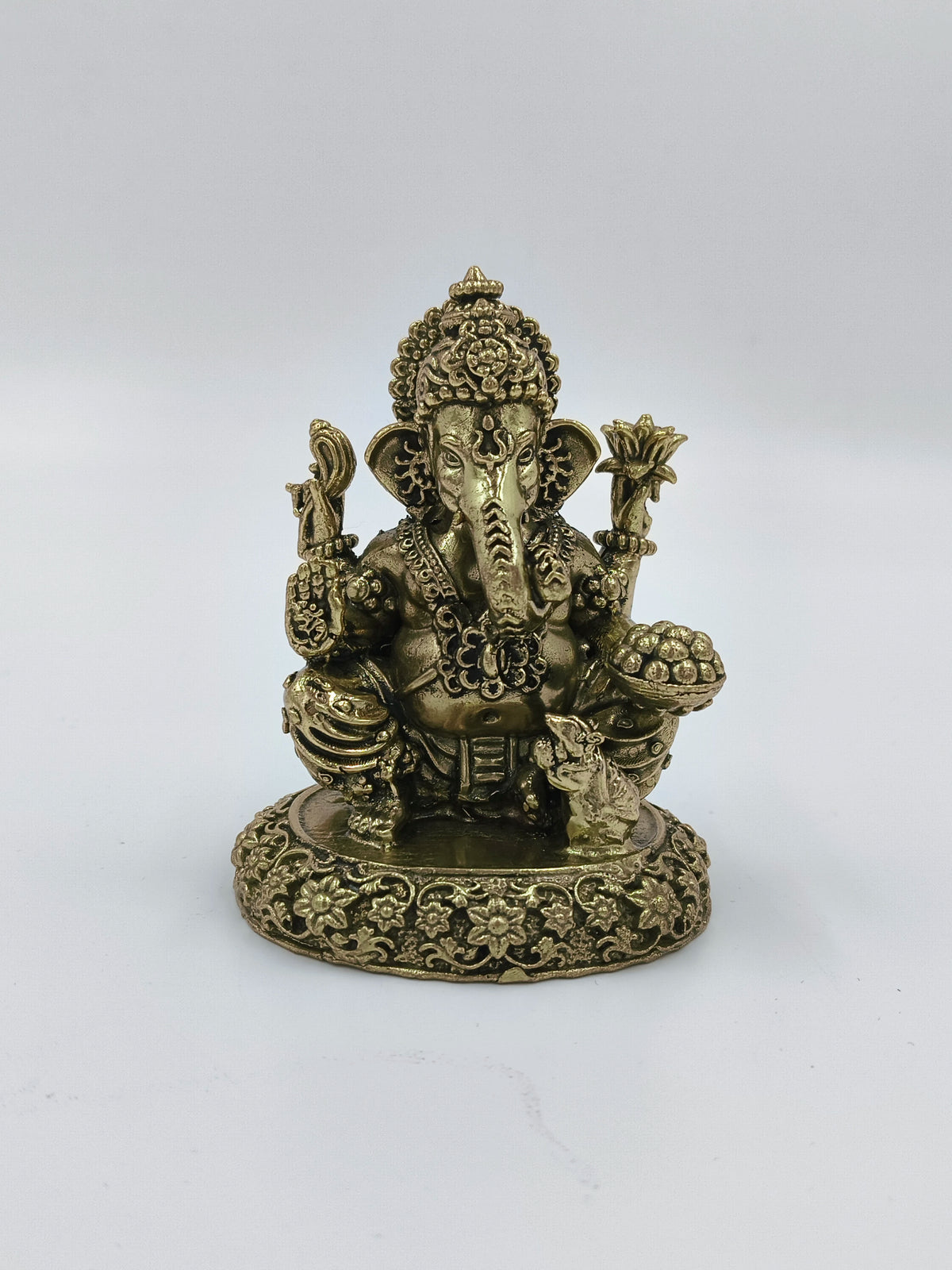 Small brass statue of sitting Ganesh with intricate floral base