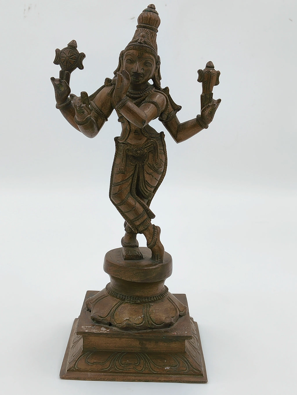 Large bronze Krishna sculpture standing on a decorated square base