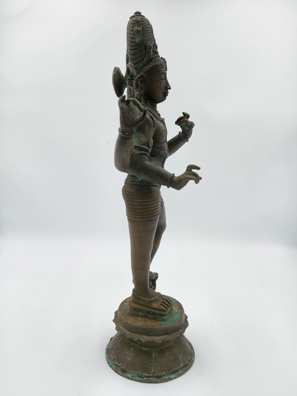 Side view of a large bronze standing Shiva statue on a lotus pedestal