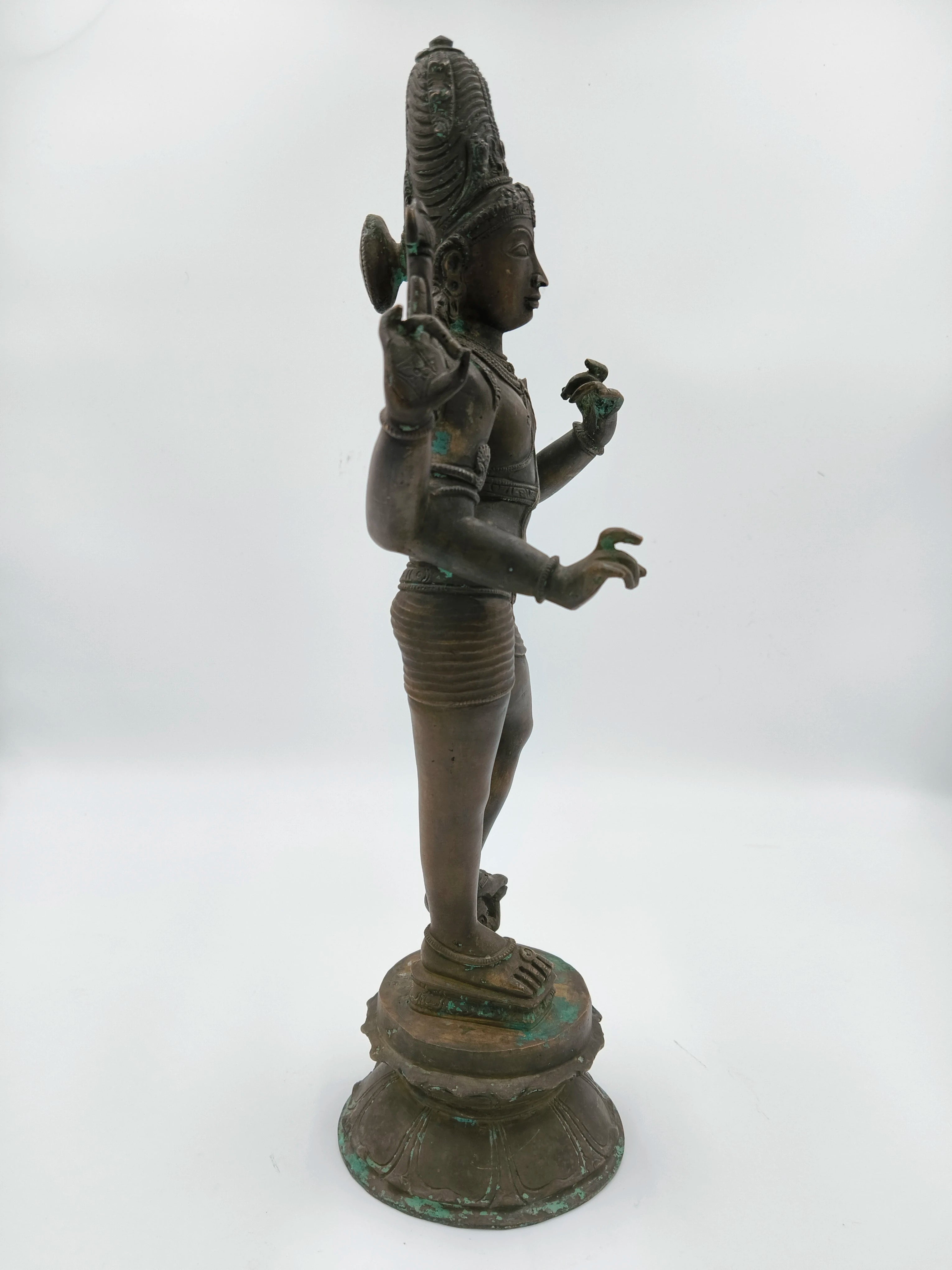 Side view of a large bronze standing Shiva statue on a lotus pedestal