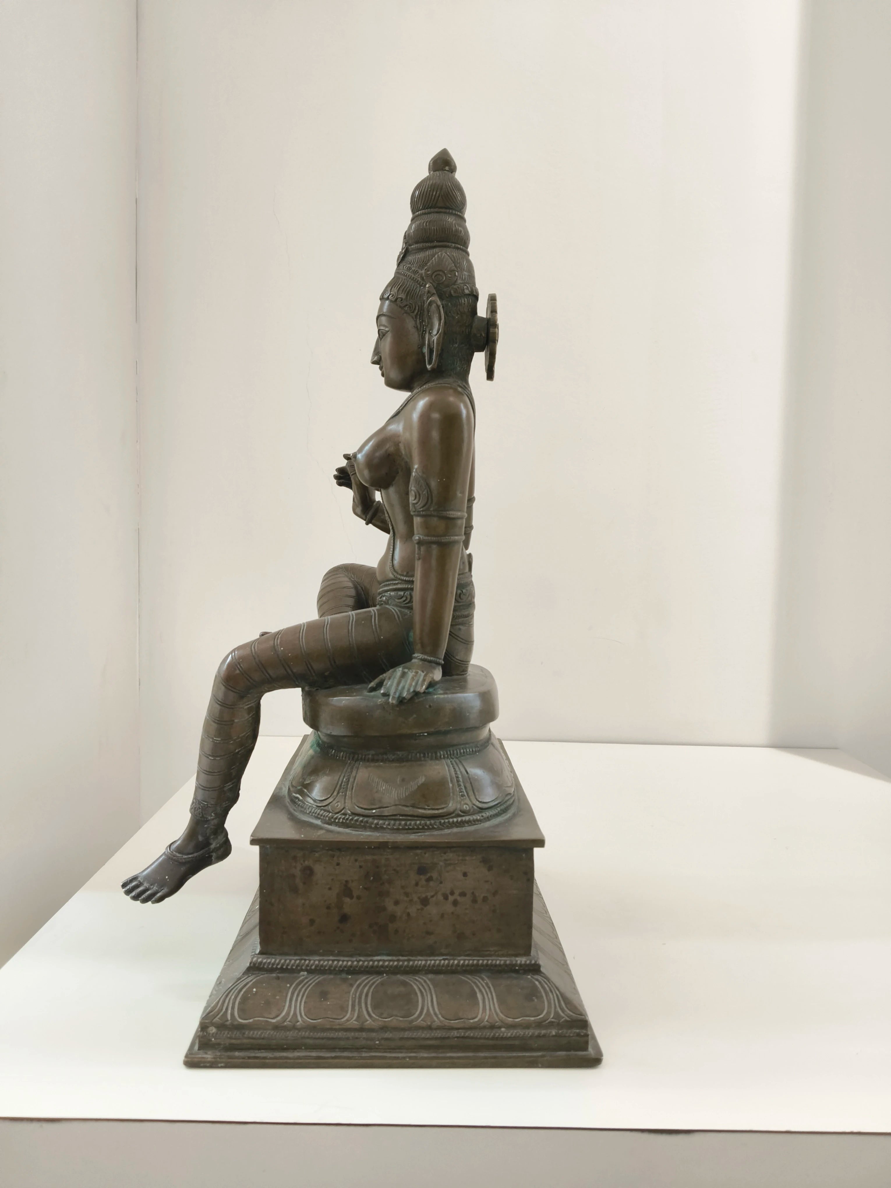 Large bronze statue of Goddess Parvathi sitting on a decorated pedestal side view