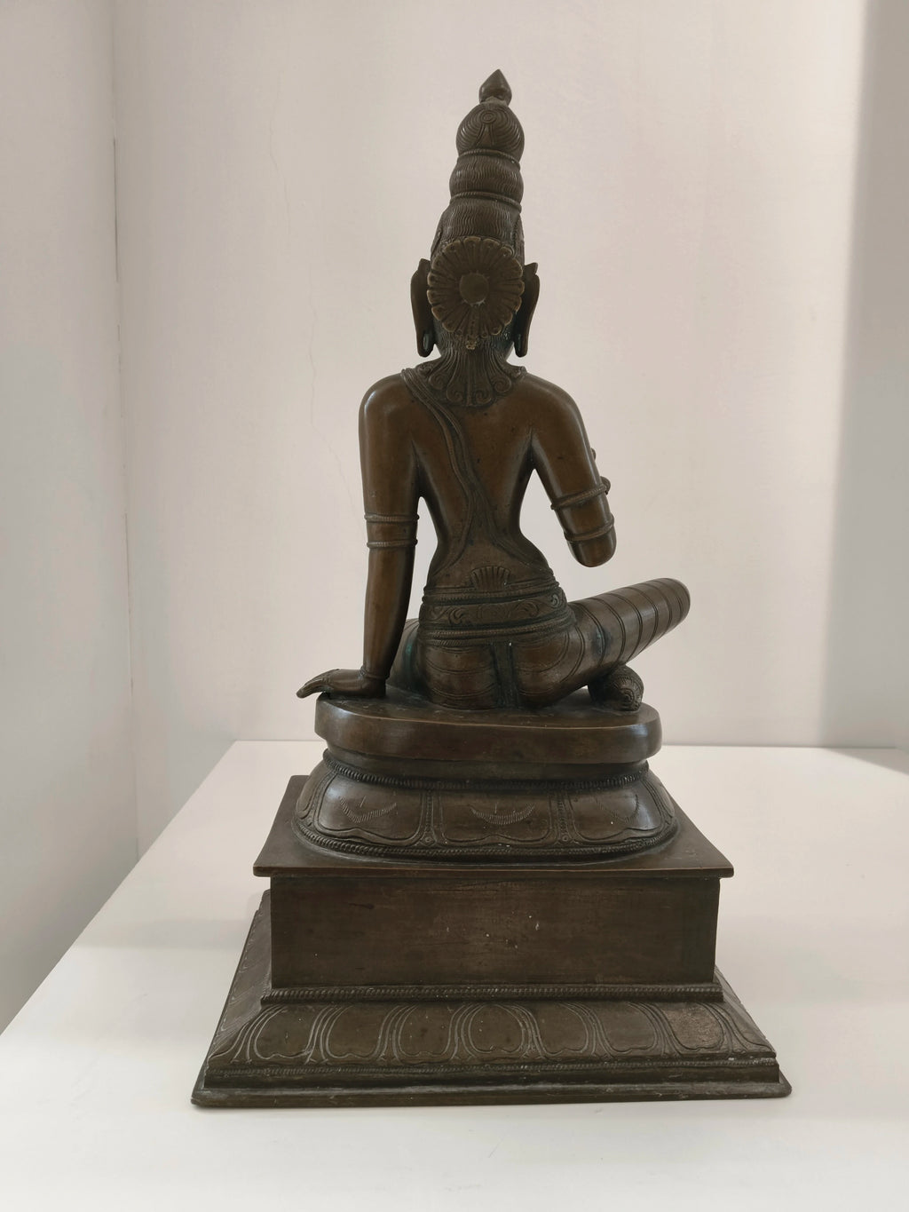 Large bronze statue of Goddess Parvathi sitting on a decorative base, back view
