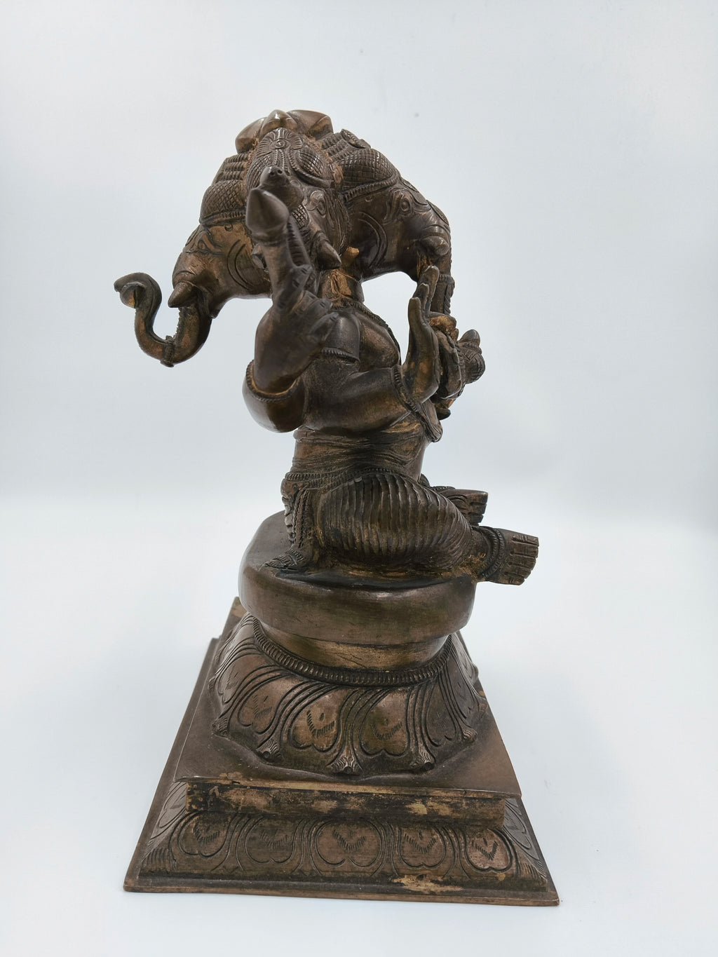 Bronze sculpture of four-faced Ganesh seated on lotus pedestal side view