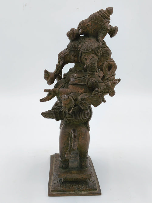 Back view of bronze statue of Ganesh with five faces standing on rectangular base