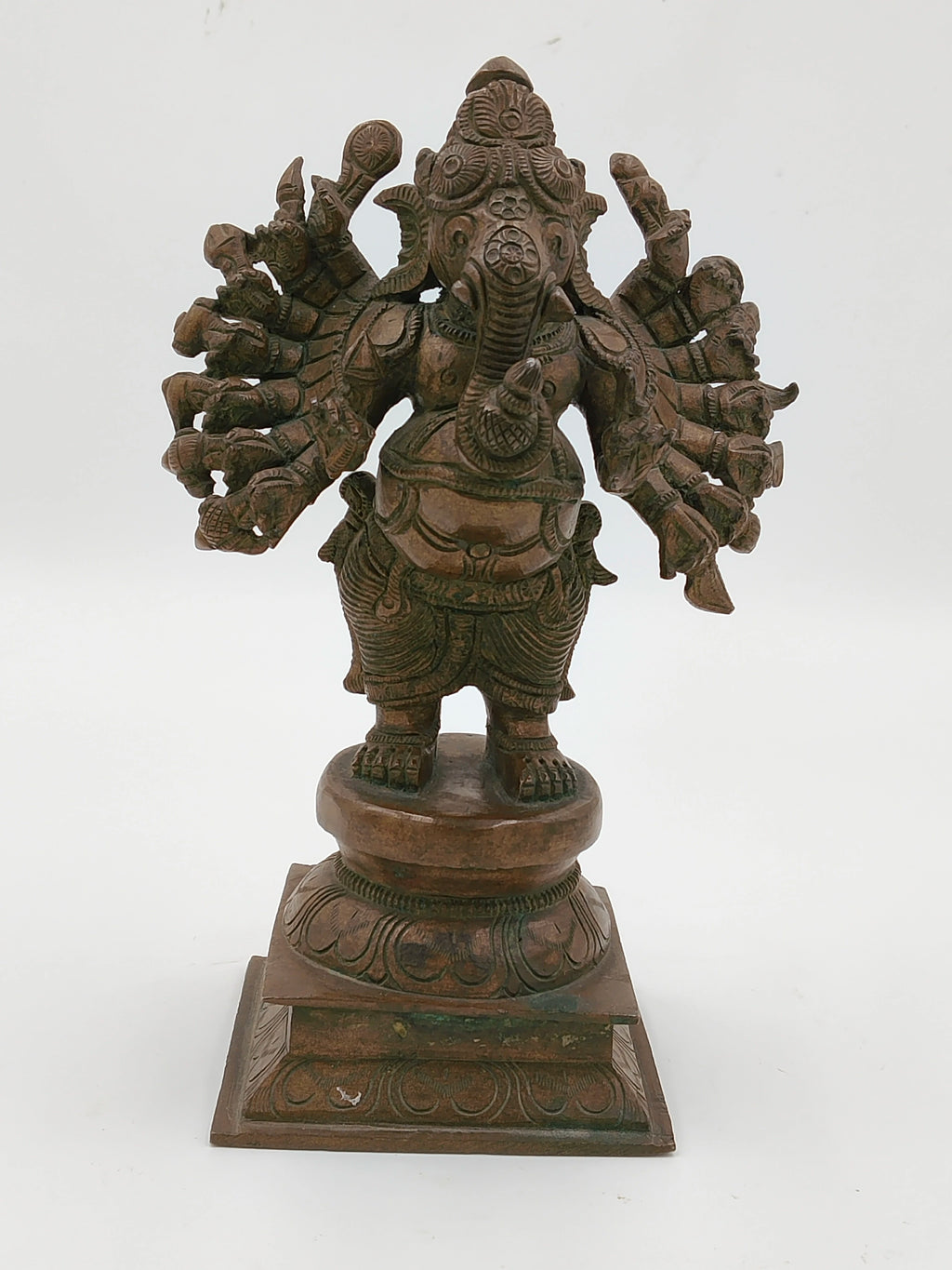 Front view of bronze Ganesh sculpture with 16 intricately detailed hands on pedestal