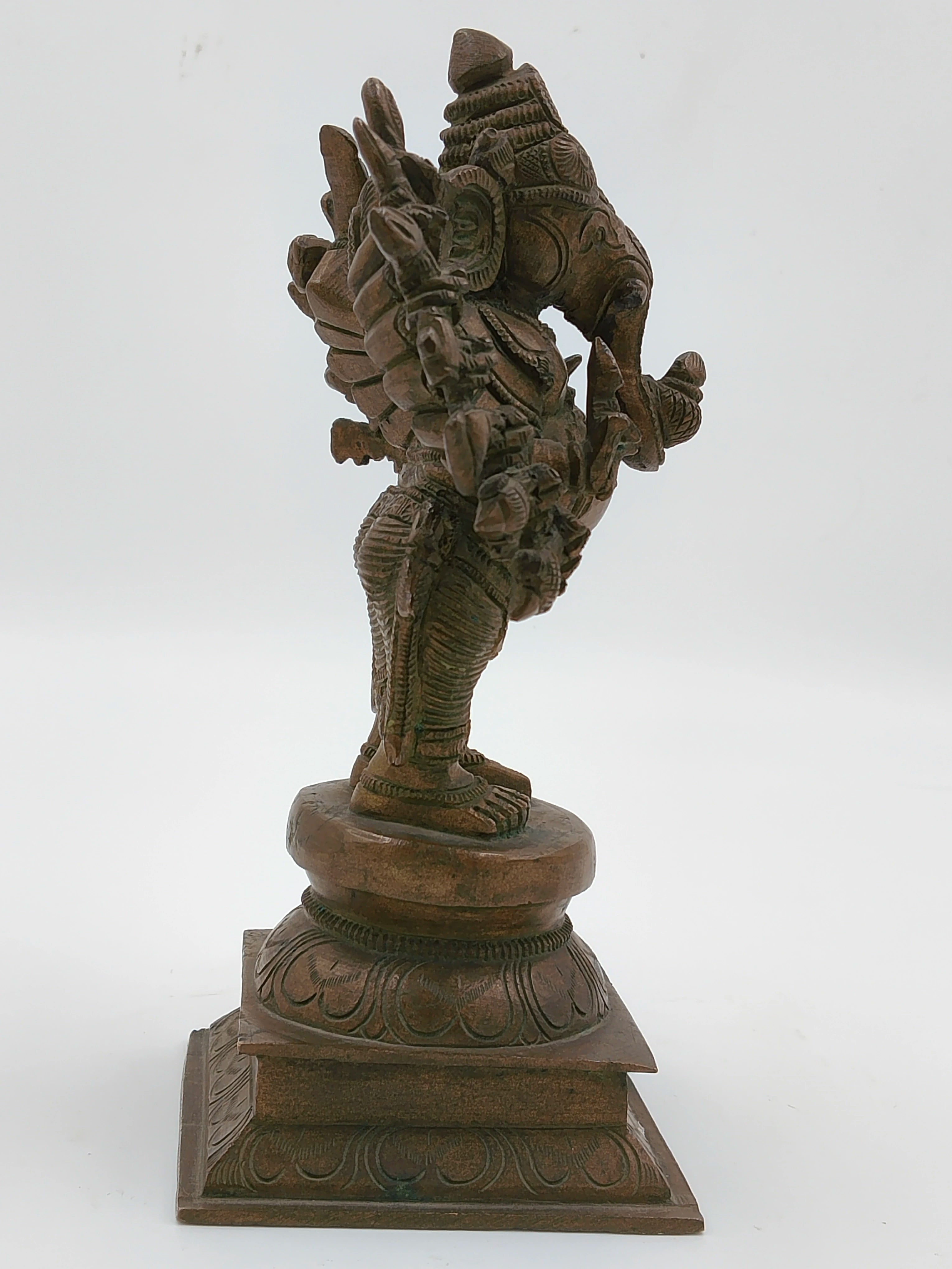 Side view of bronze Ganesh statue with 16 hands on decorative base