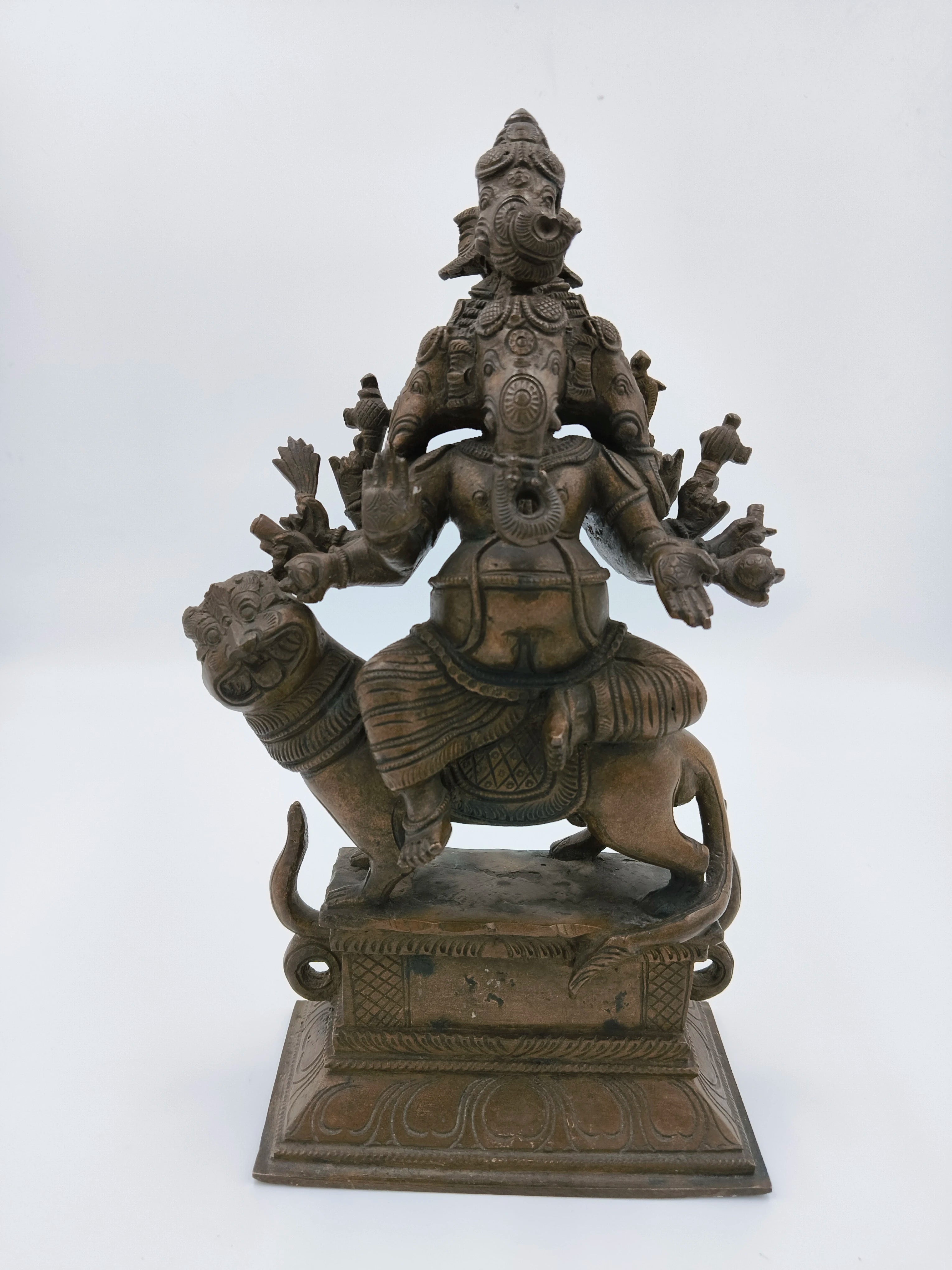 Bronze sculpture of five-faced Ganesh seated on a lion, detailed with multiple arms