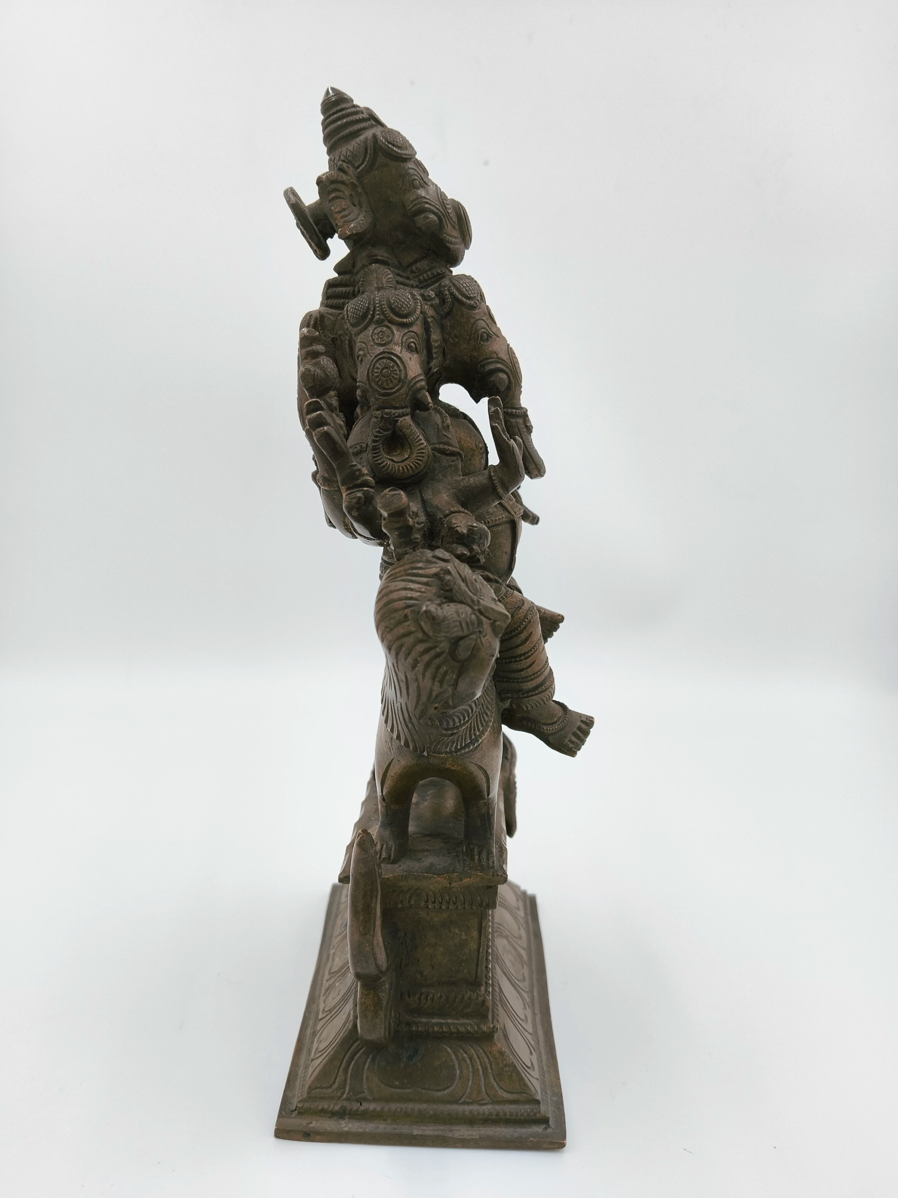 Side view of a large bronze Ganesh statue with five faces and intricate carvings