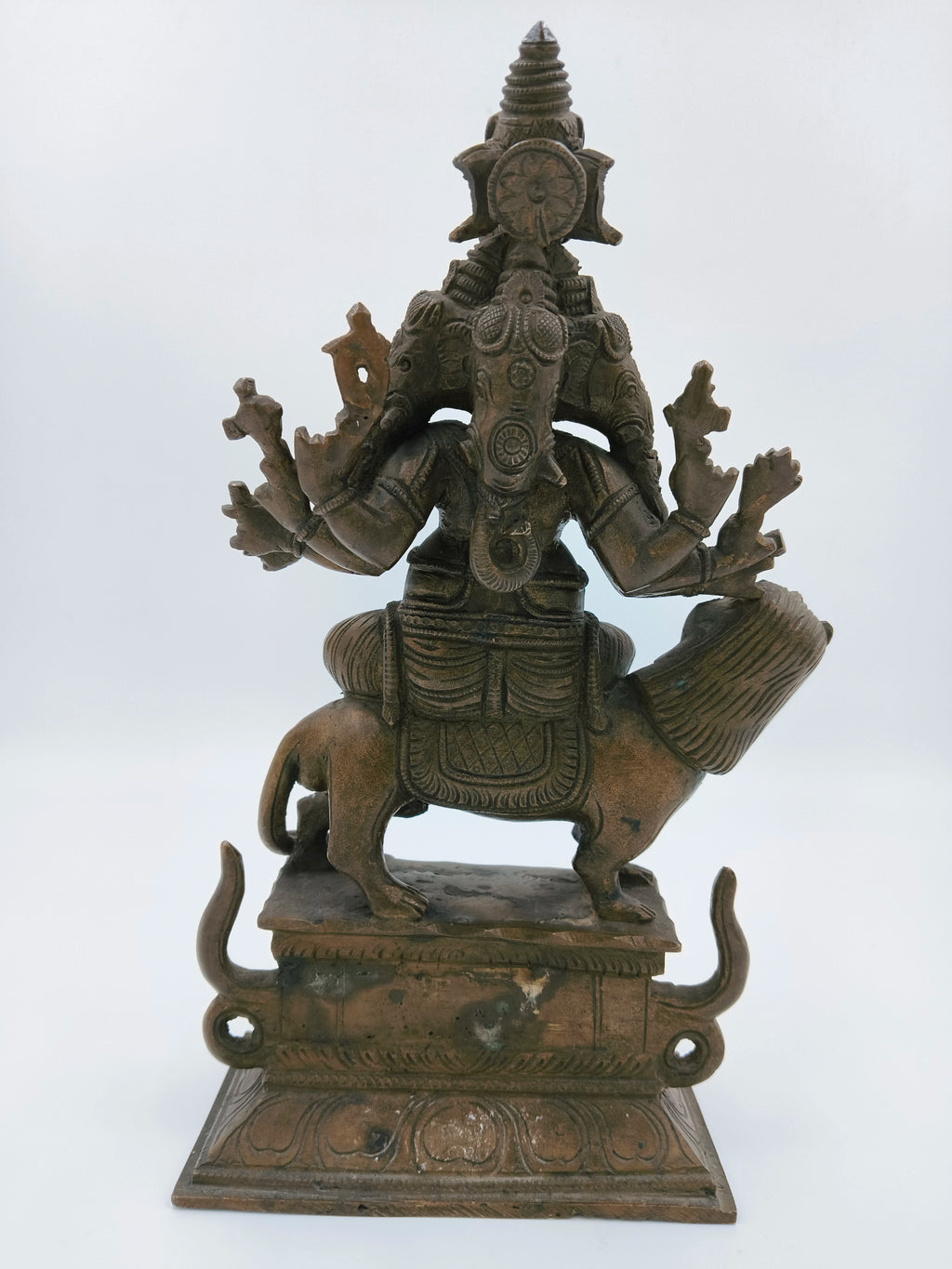 Rear view of bronze Ganesh statue with five faces seated on a mouse
