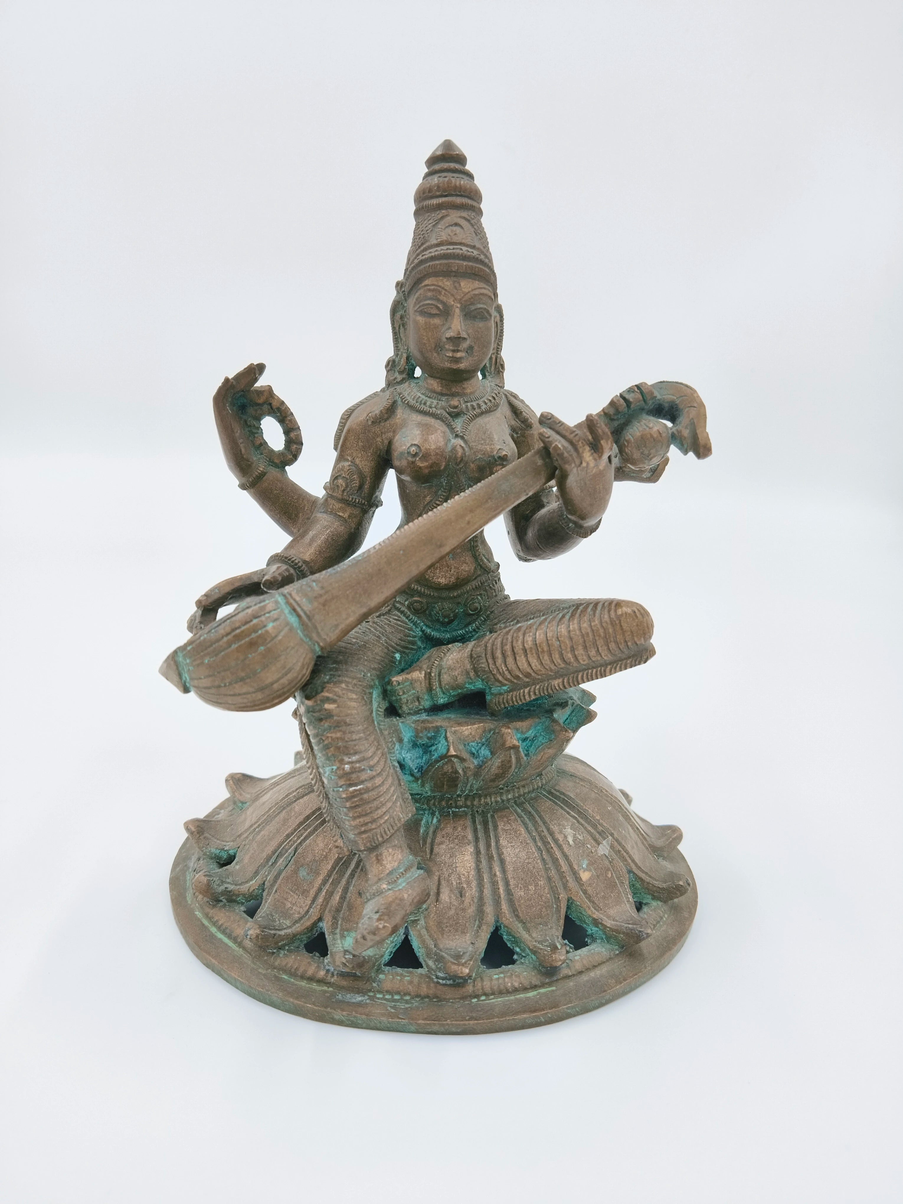 Bronze sculpture of Saraswathi goddess playing veena, seated on lotus base