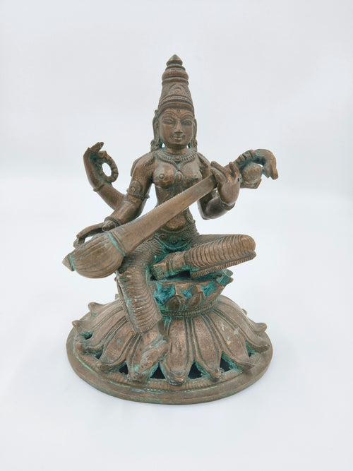 Bronze sculpture of Saraswathi goddess playing veena, seated on lotus base