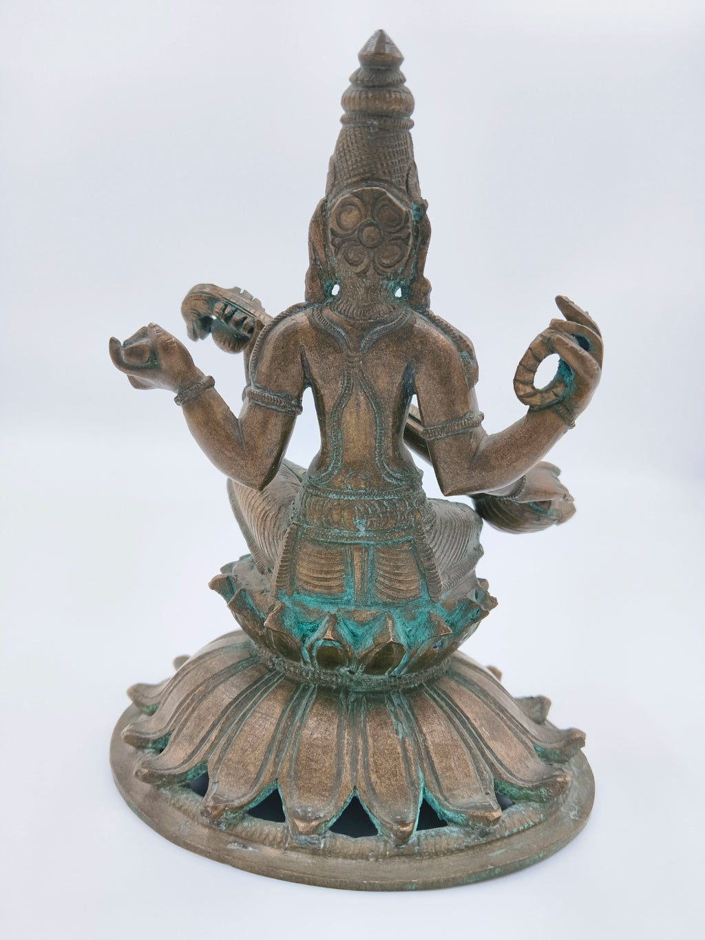 Back view of bronze Saraswathi sculpture seated on lotus base