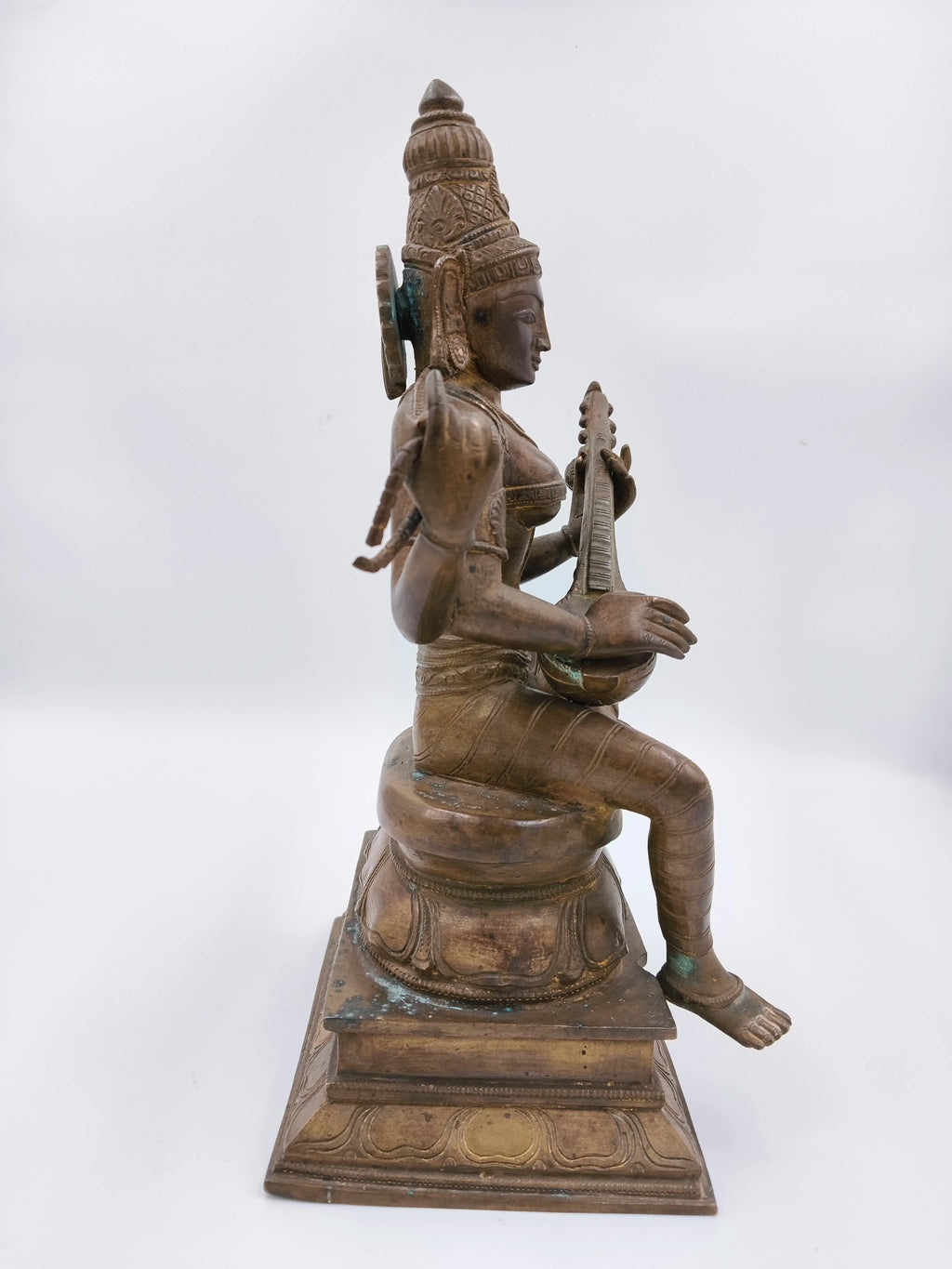 Side view of large bronze Saraswathi statue seated playing veena