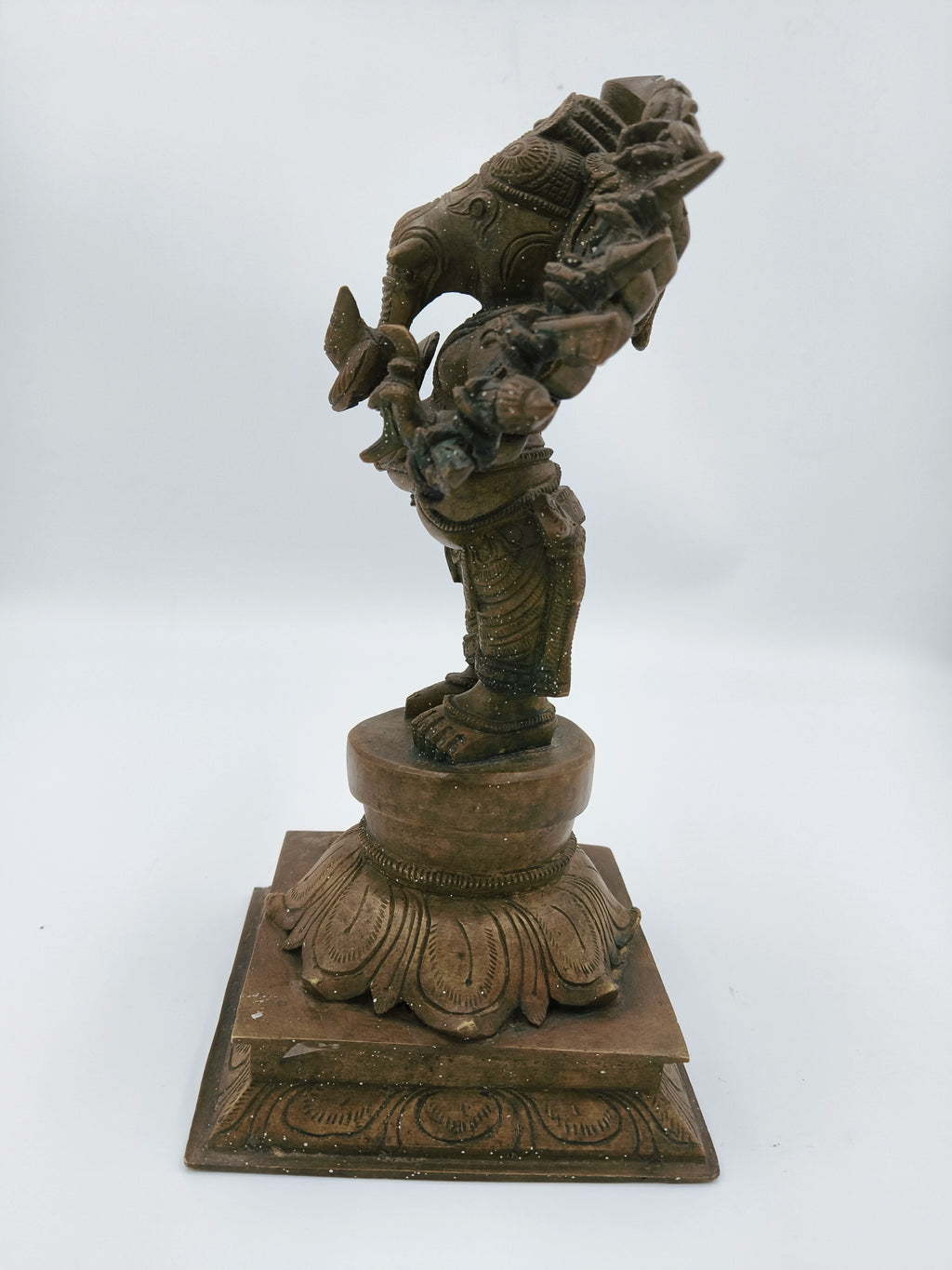 Side view of bronze Ganesh statue on decorative pedestal