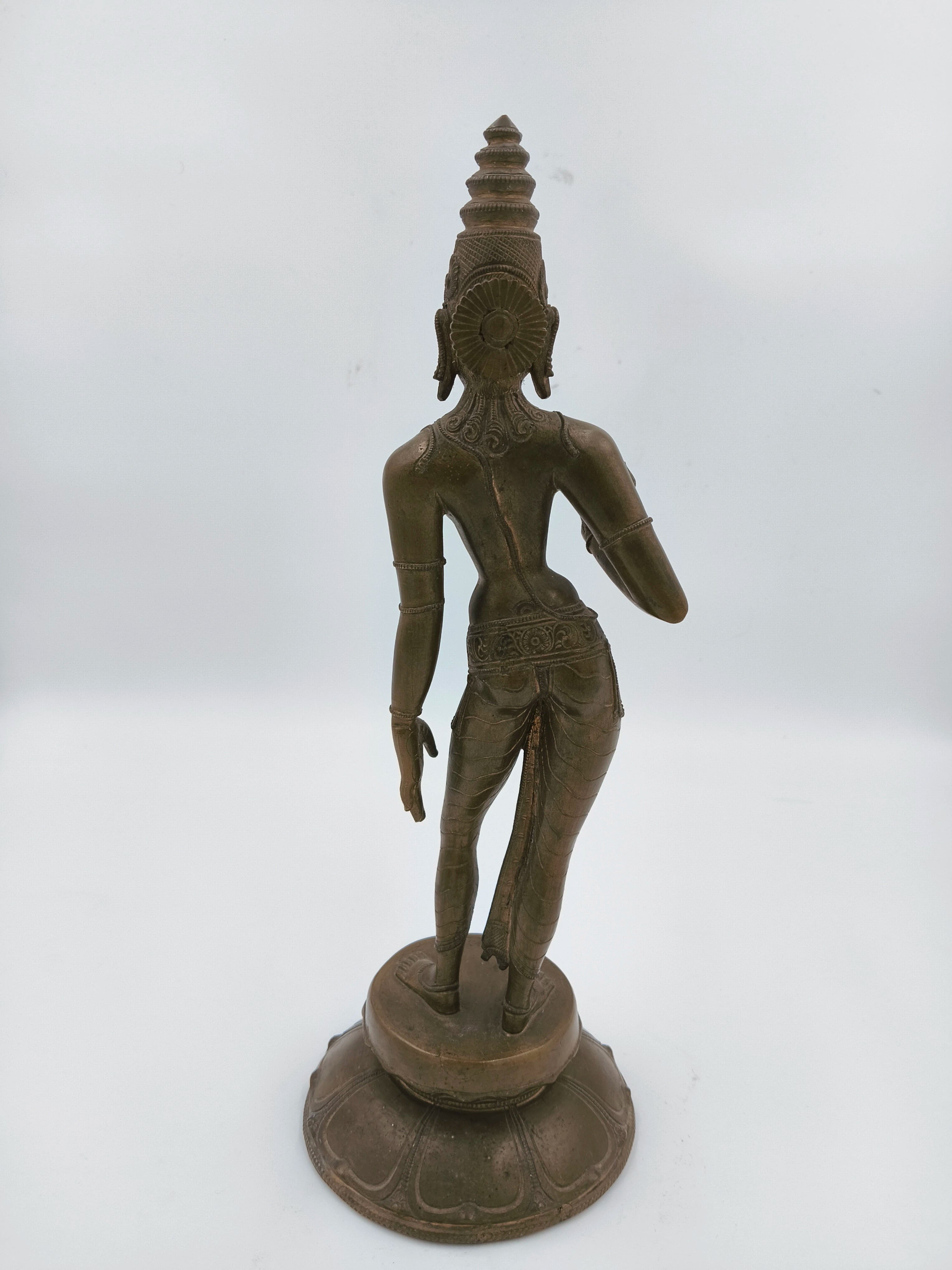 Back view of bronze standing Parvathi sculpture with detailed attire and headdress