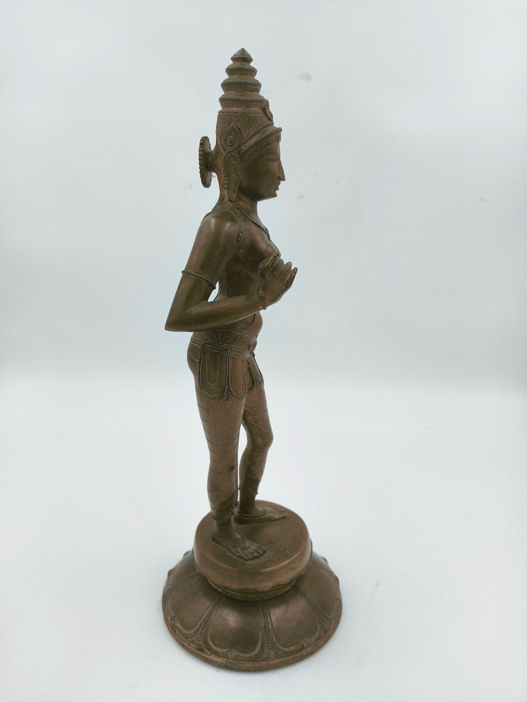 Side view of a large bronze standing Parvathi statue on a round base
