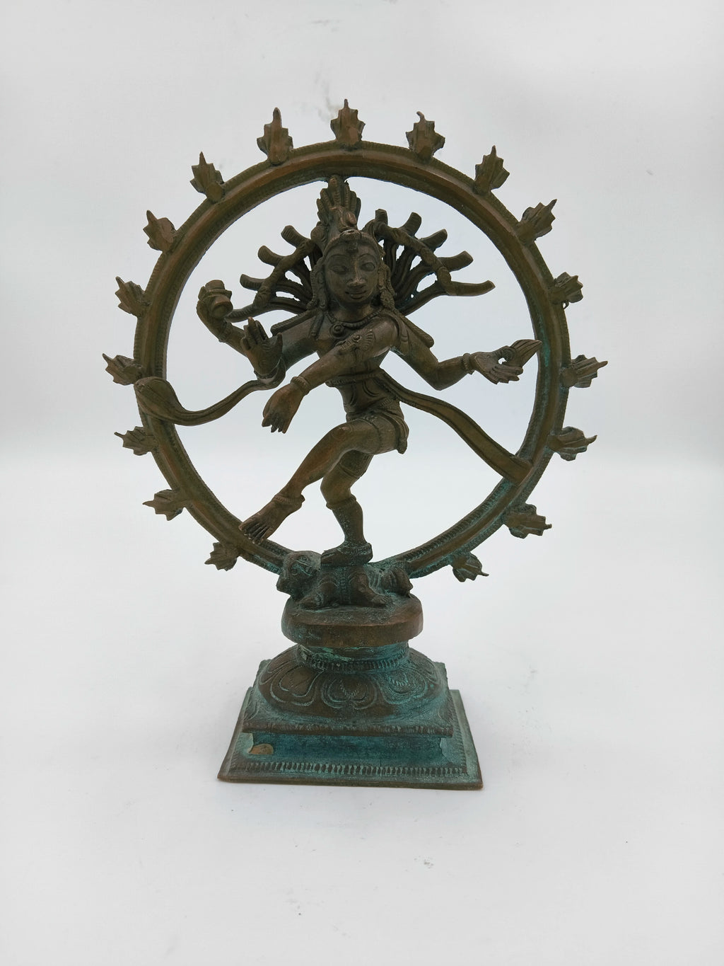 Bronze Nataraja sculpture depicting a dancing Shiva with multiple arms inside a circular frame