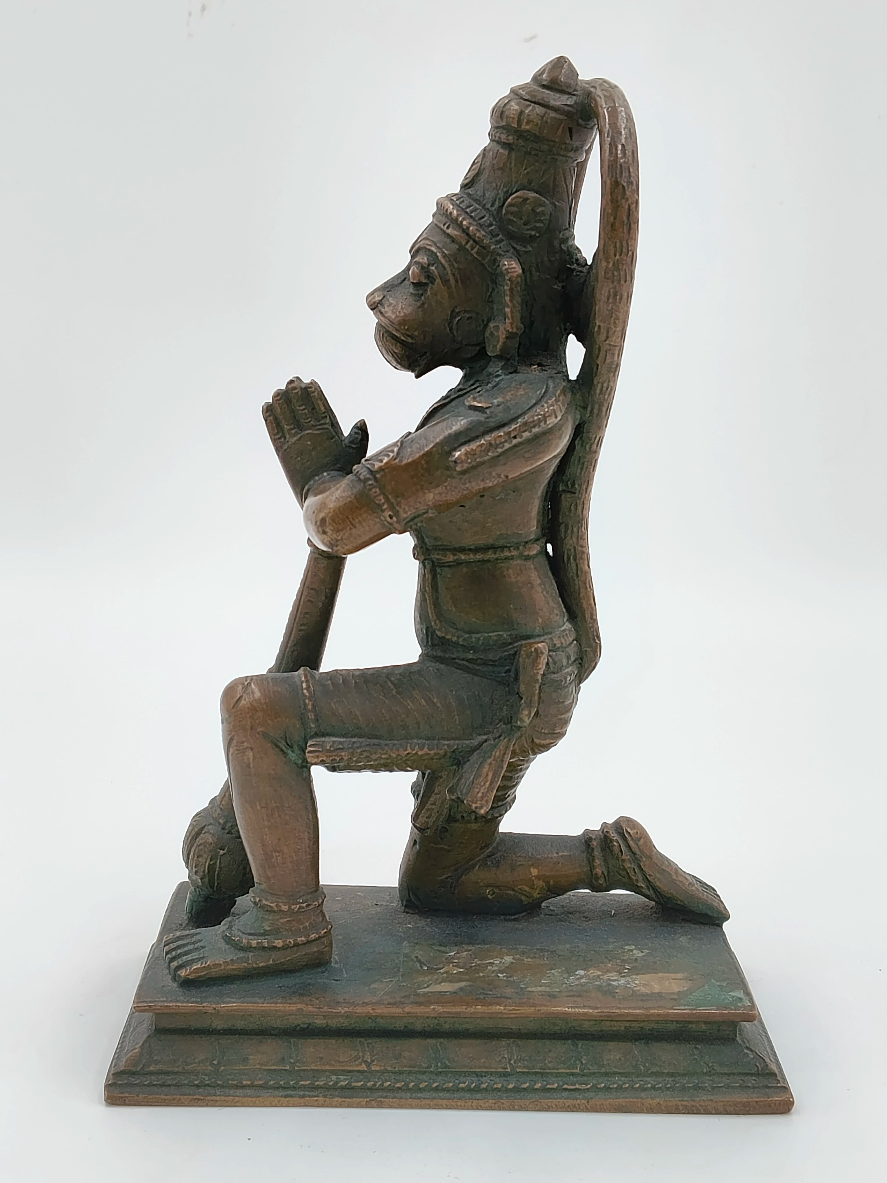 Side view of a 7-inch bronze Hanuman sculpture kneeling with joined hands