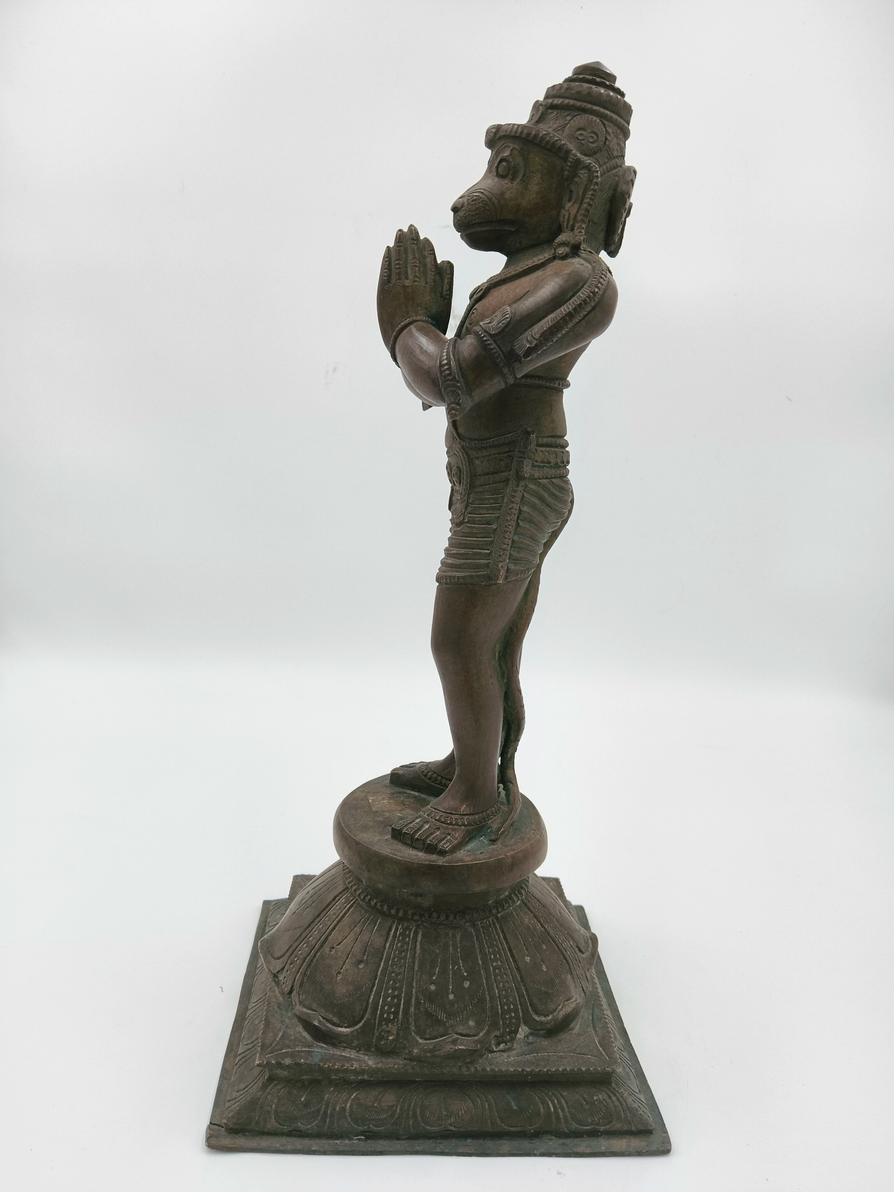 Side view of bronze Hanuman statue with Namaskaram hands on lotus base