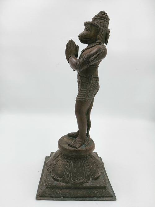 Side view of bronze Hanuman statue with Namaskaram hands on lotus base