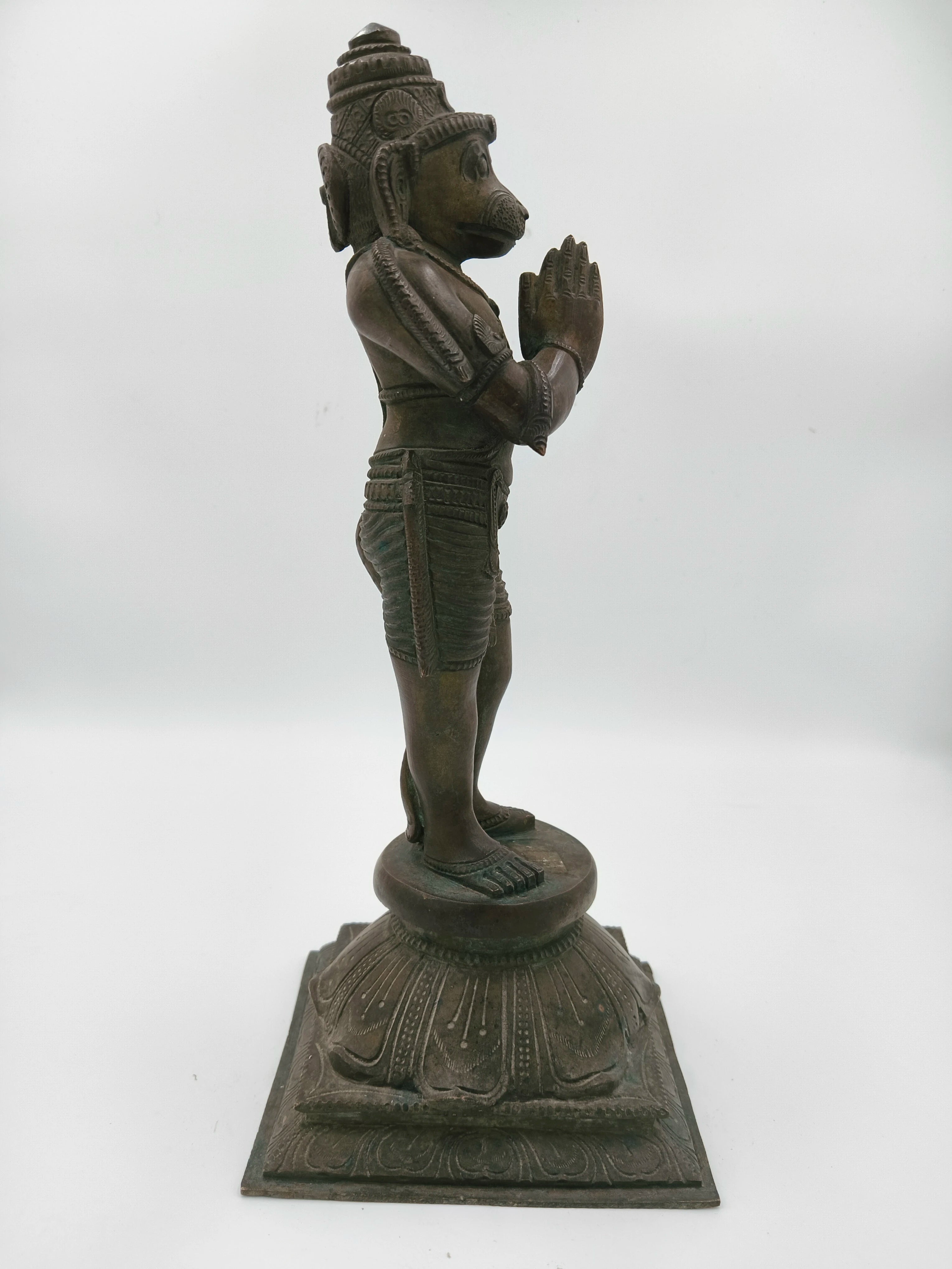 Side view of bronze Hanuman statue standing with hands in namaskaram pose