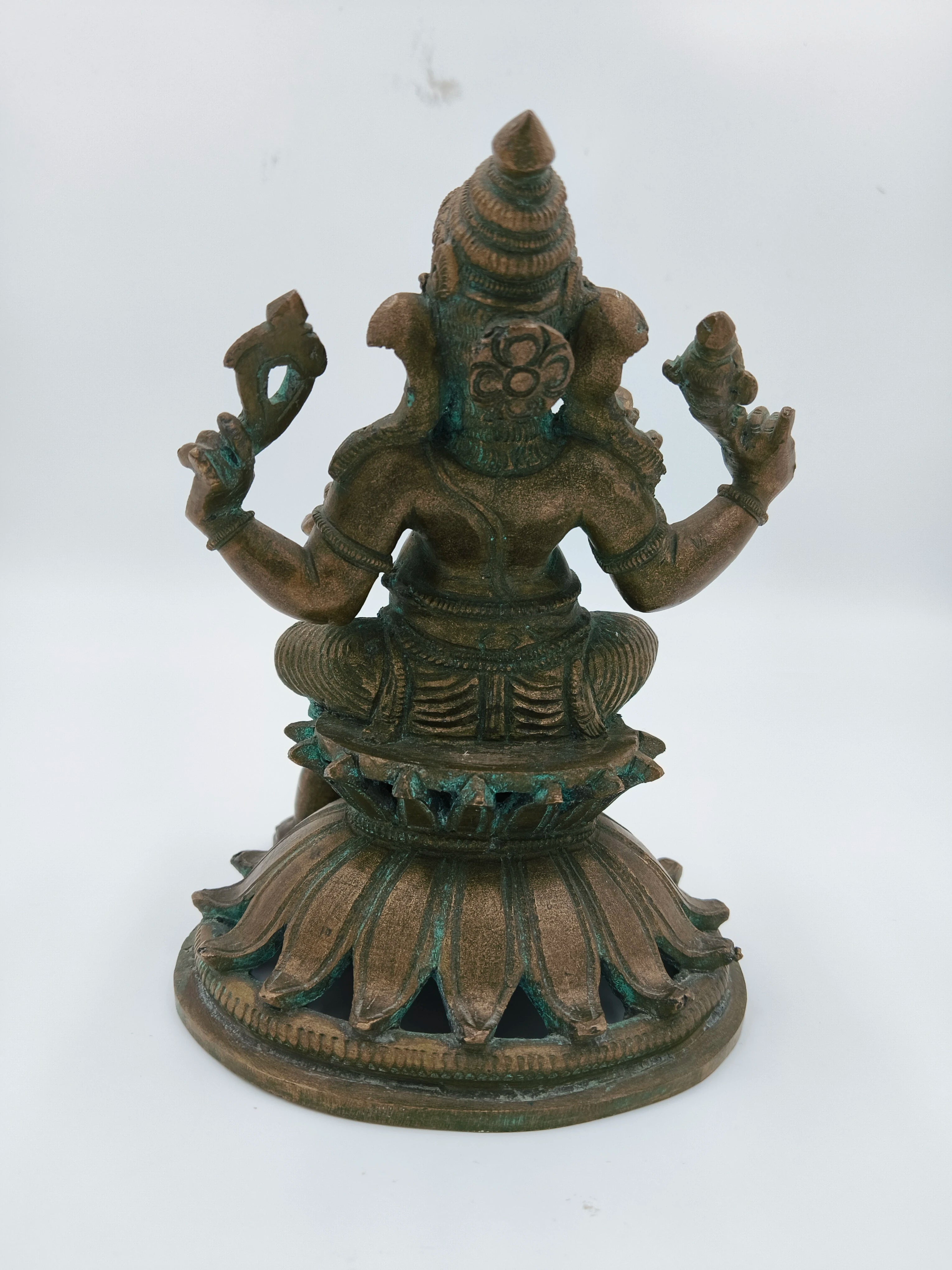 Back view of bronze Ganesh statue seated on lotus base with mice details