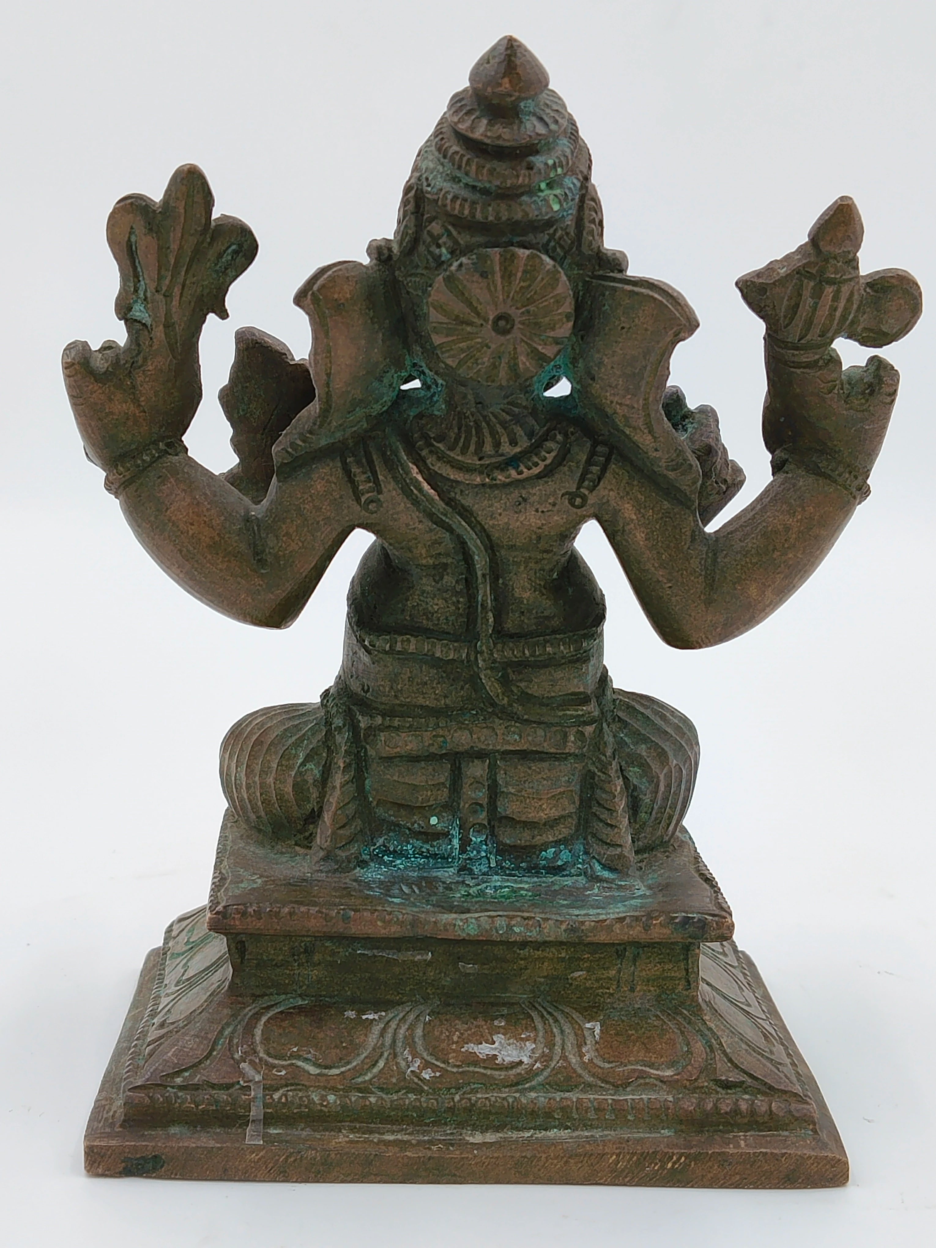 Back view of a medium bronze Ganesh statue seated on a decorative base