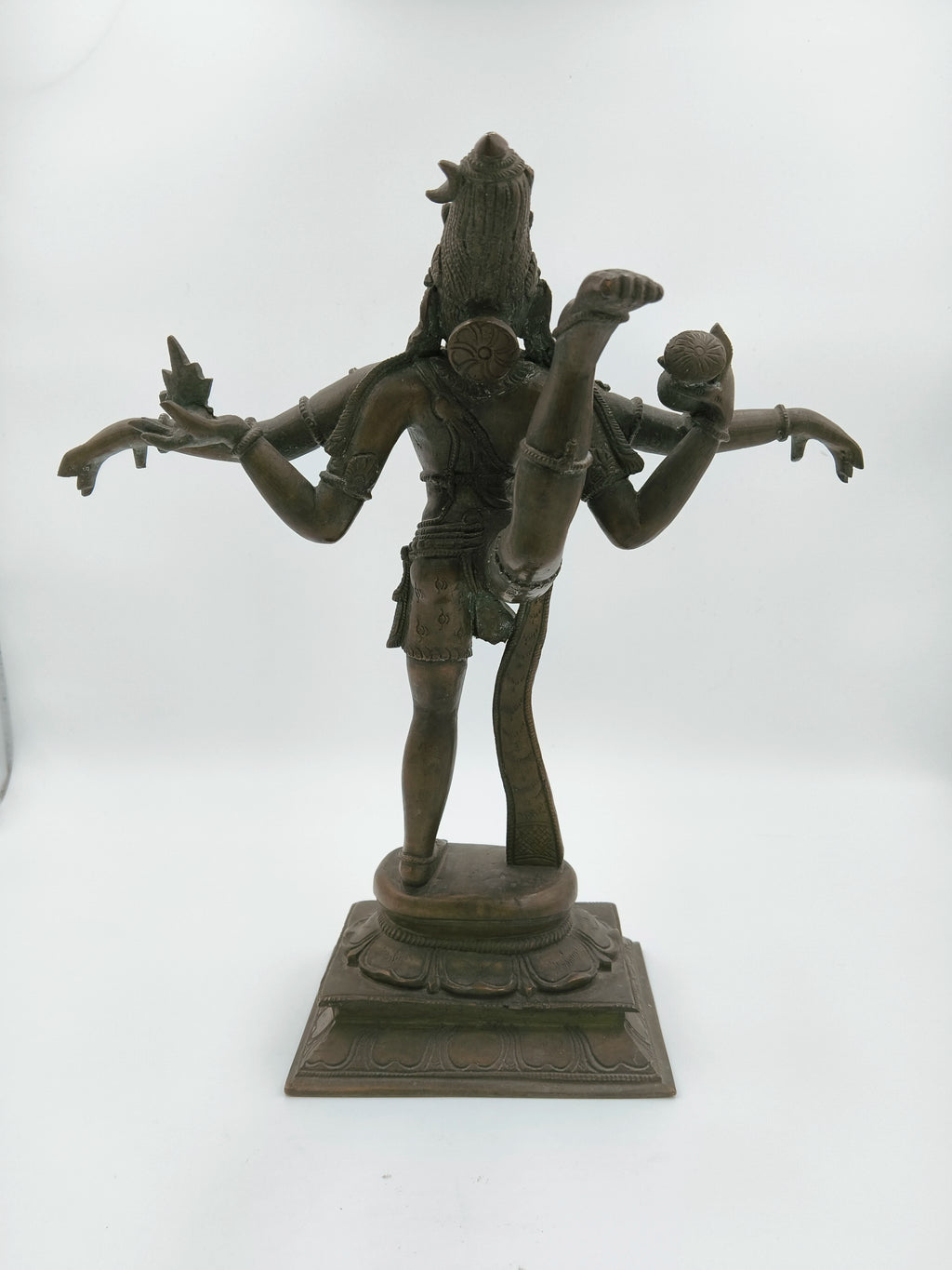 Rear view of bronze Nataraja sculpture with multiple arms and raised leg on ornate base