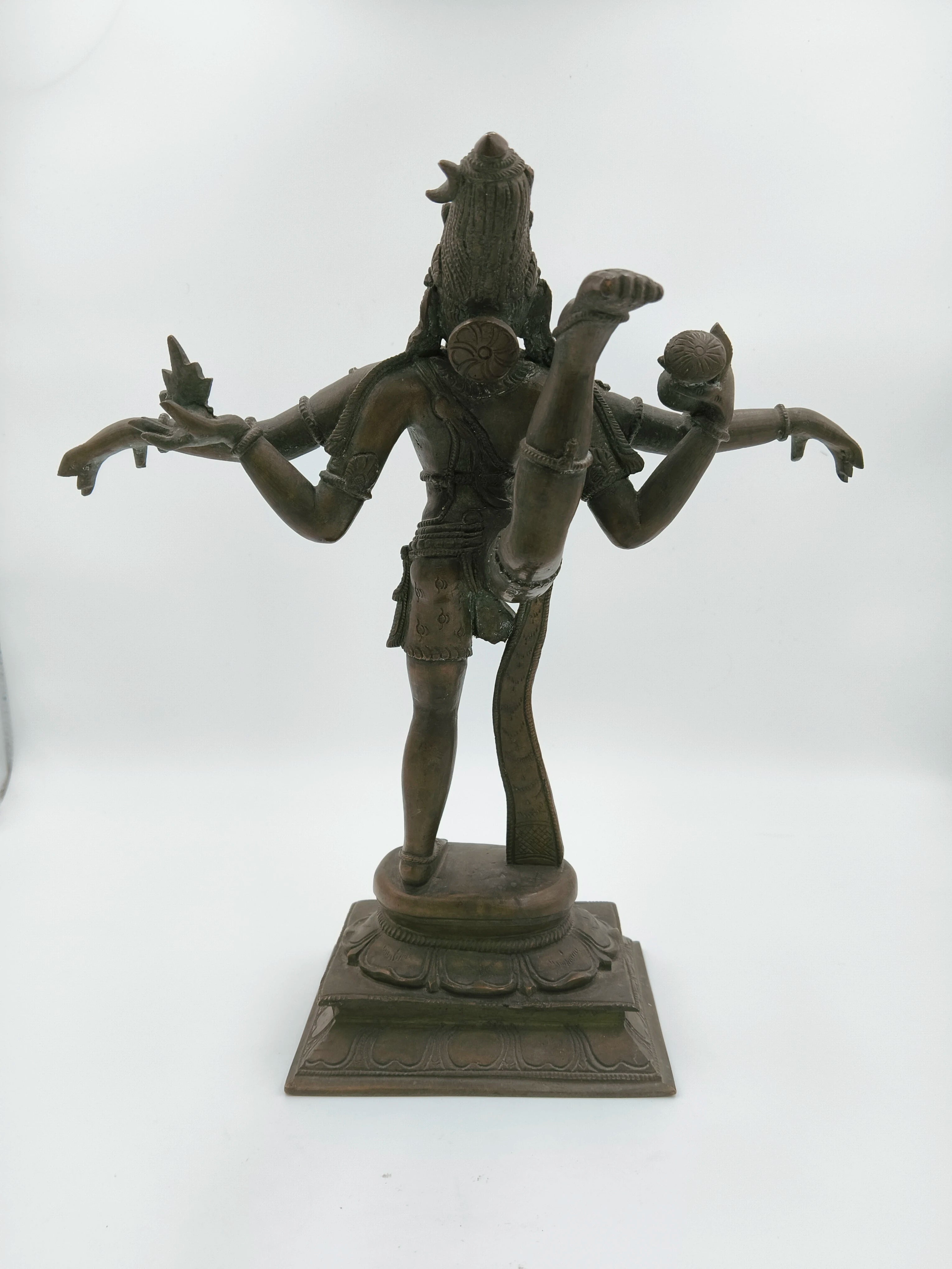 Rear view of bronze Nataraja sculpture with multiple arms and raised leg on ornate base